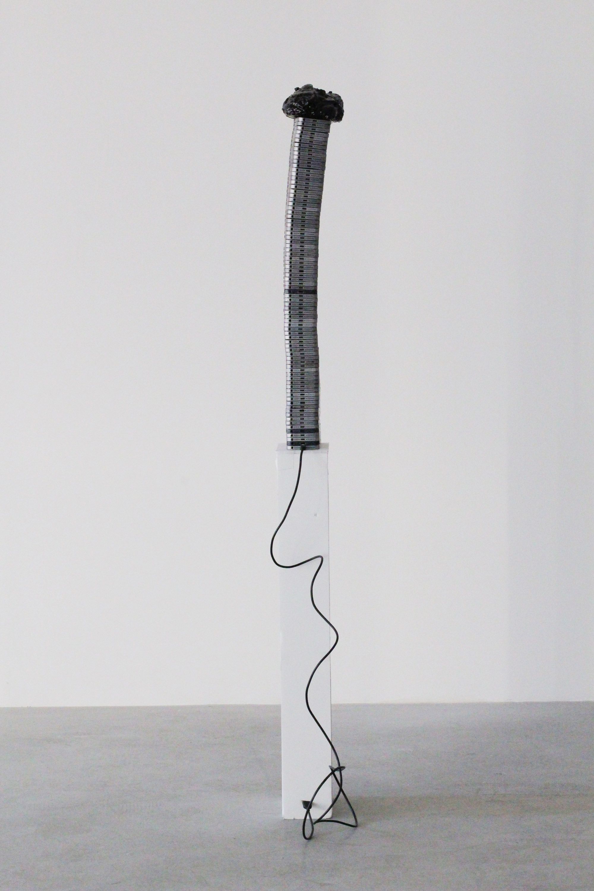 Untitled (Too Thick) | 2018 | Aluminum phone casings, silicone, polyurethane, asphalt, wood, Lightning to USB cord
