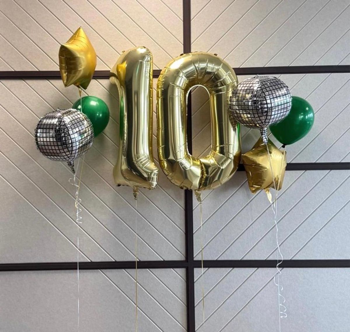 Gold number 10 balloons with gold star, green and disco ball balloons celebrating 10 years of Volanteus