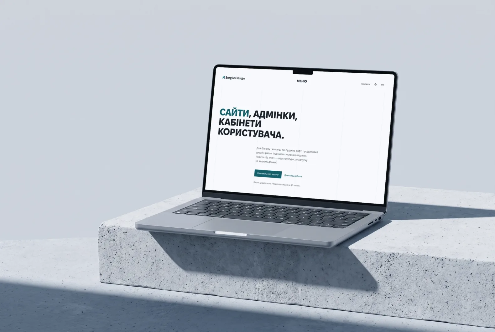 Ноутбук на бетонному блоці з головною sergiusdesign.com: заголовок «Сайти, адмінки, кабінети користувача» і кнопка «Розкажіть про задачу», світла тема