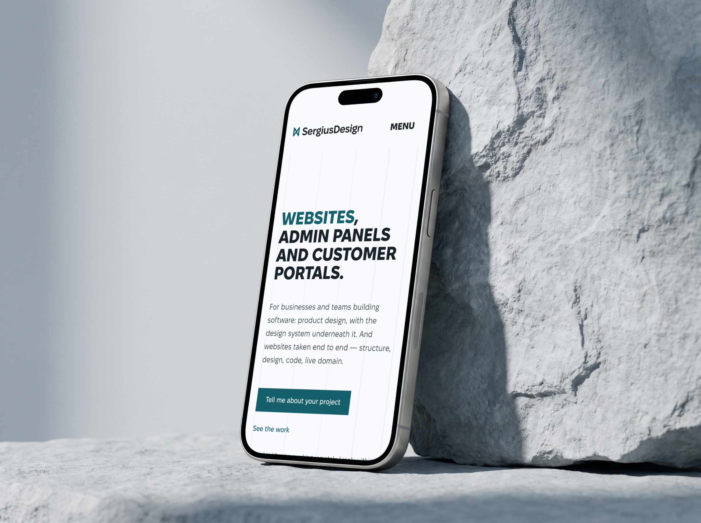 Phone against a pale stone with the sergiusdesign.com home page in English: the headline “Websites, admin panels and customer portals” and the “Tell me about your project” button