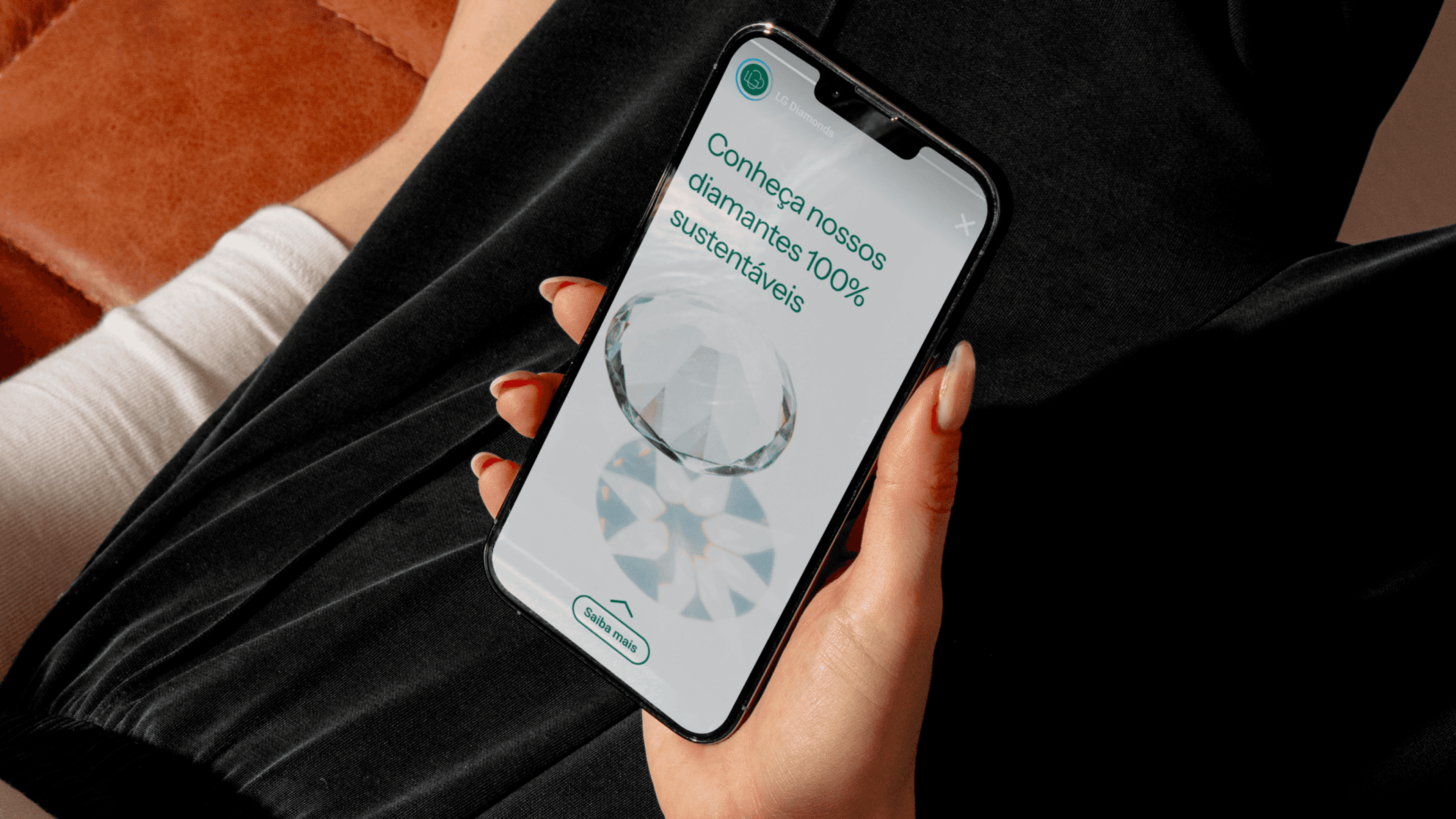 Mão segurando um iPhone com anúncio da LG Diamonds: diamante lapidado e a frase 'Conheça nossos diamantes 100% sustentáveis'