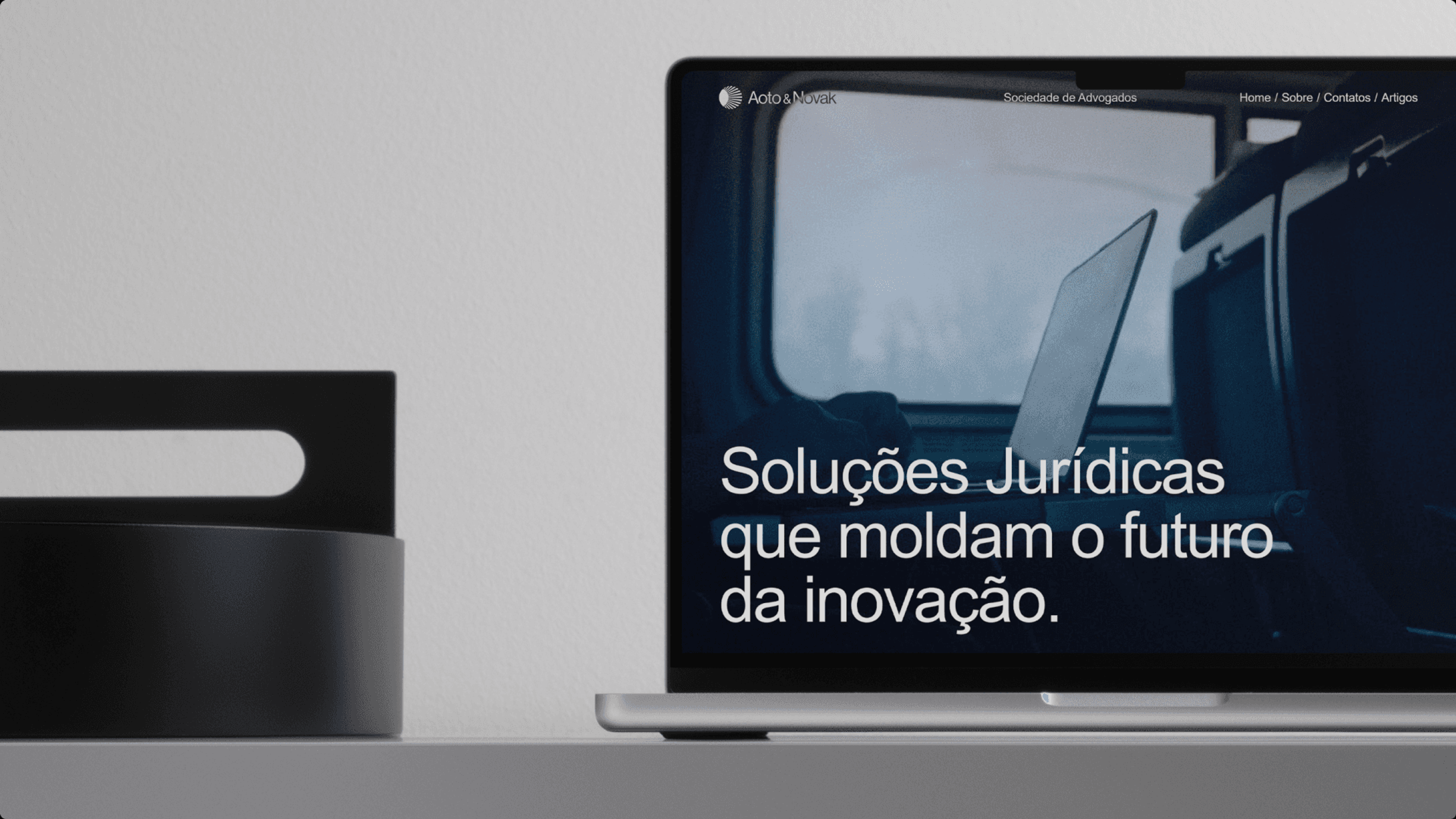 Site da Aoto & Novak num notebook, com o título Soluções Jurídicas que moldam o futuro da inovação
