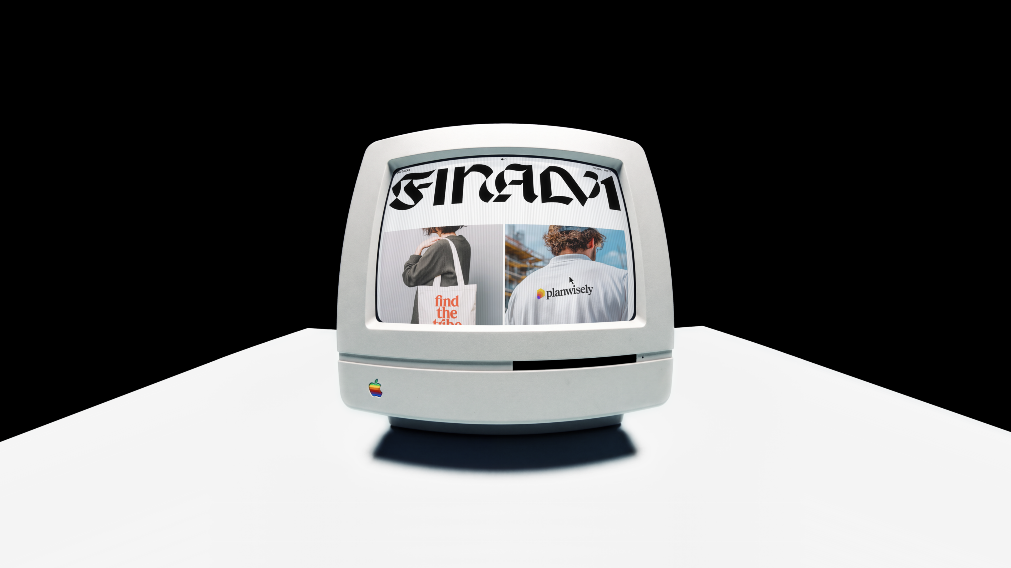 A retro Apple computer on a white table against a black wall, its screen showing the Finalv1 home: the blackletter wordmark over two project photos, a tote bag that reads find the tribe and a shirt with the Planwisely logo