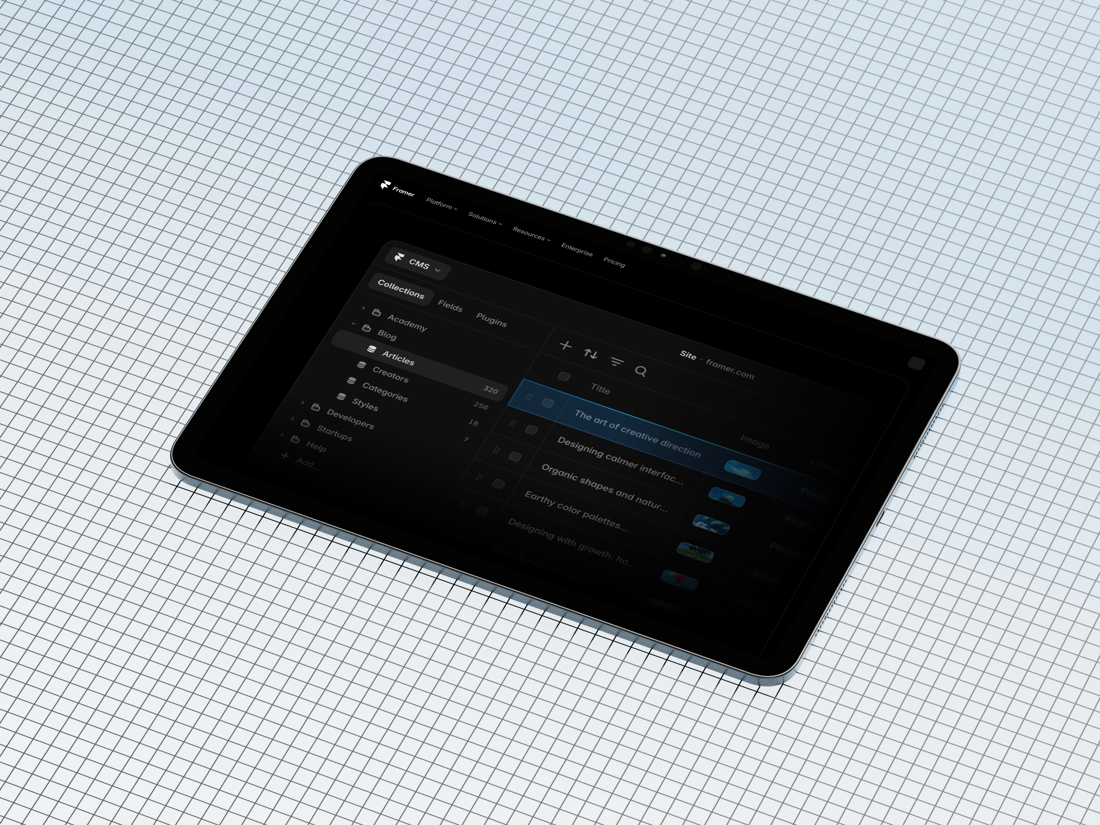 An iPad resting on grid paper, showing the Framer CMS with the Collections sidebar open and a list of blog articles