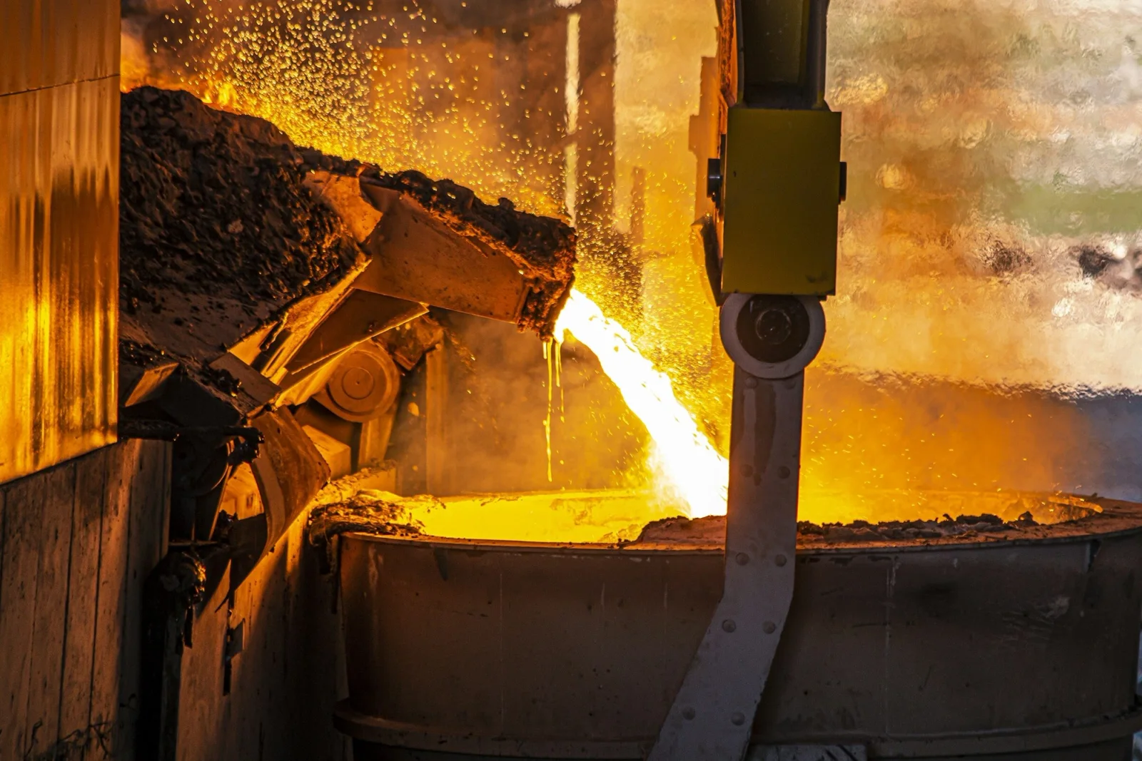 Molten metal pouring into a ladle in a foundry
