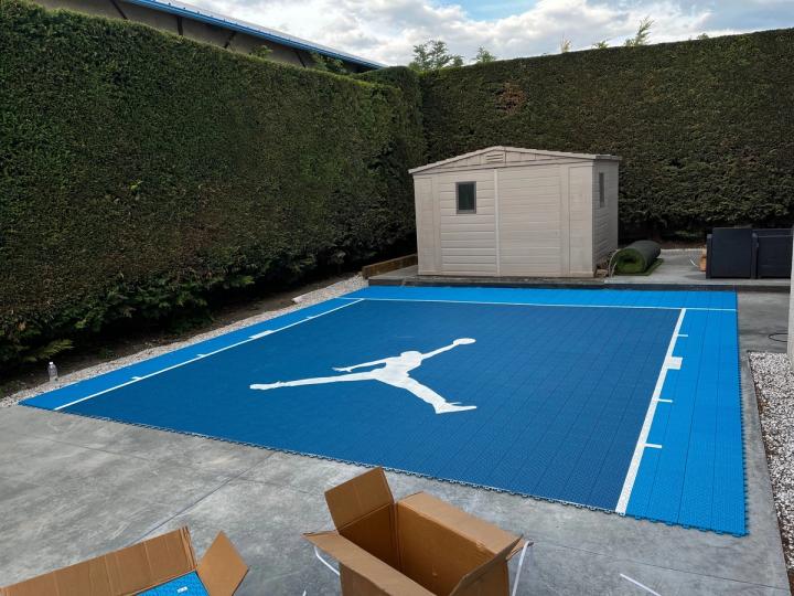 Terrain de basket en dalles Dynamic Elite bleues fraîchement posé, cartons de livraison au premier plan