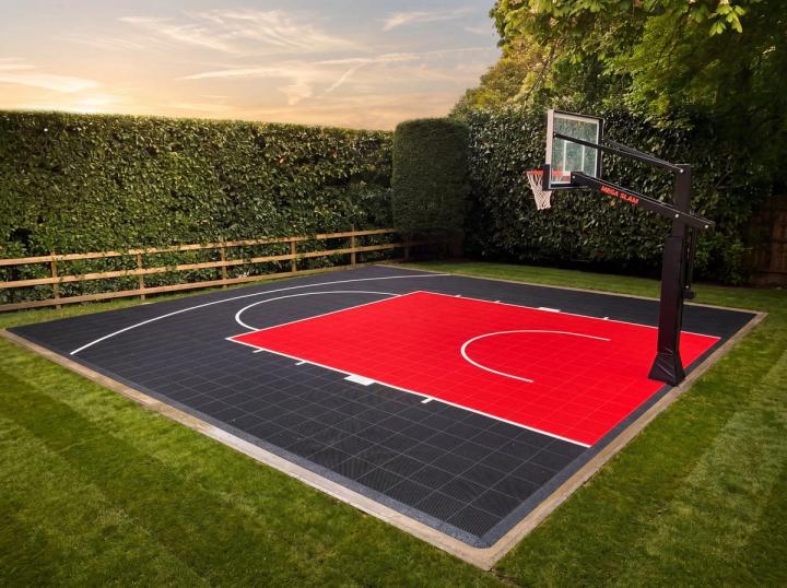 A graphite and cherry-red modular half-court in a UK back garden, with a MegaSlam hoop