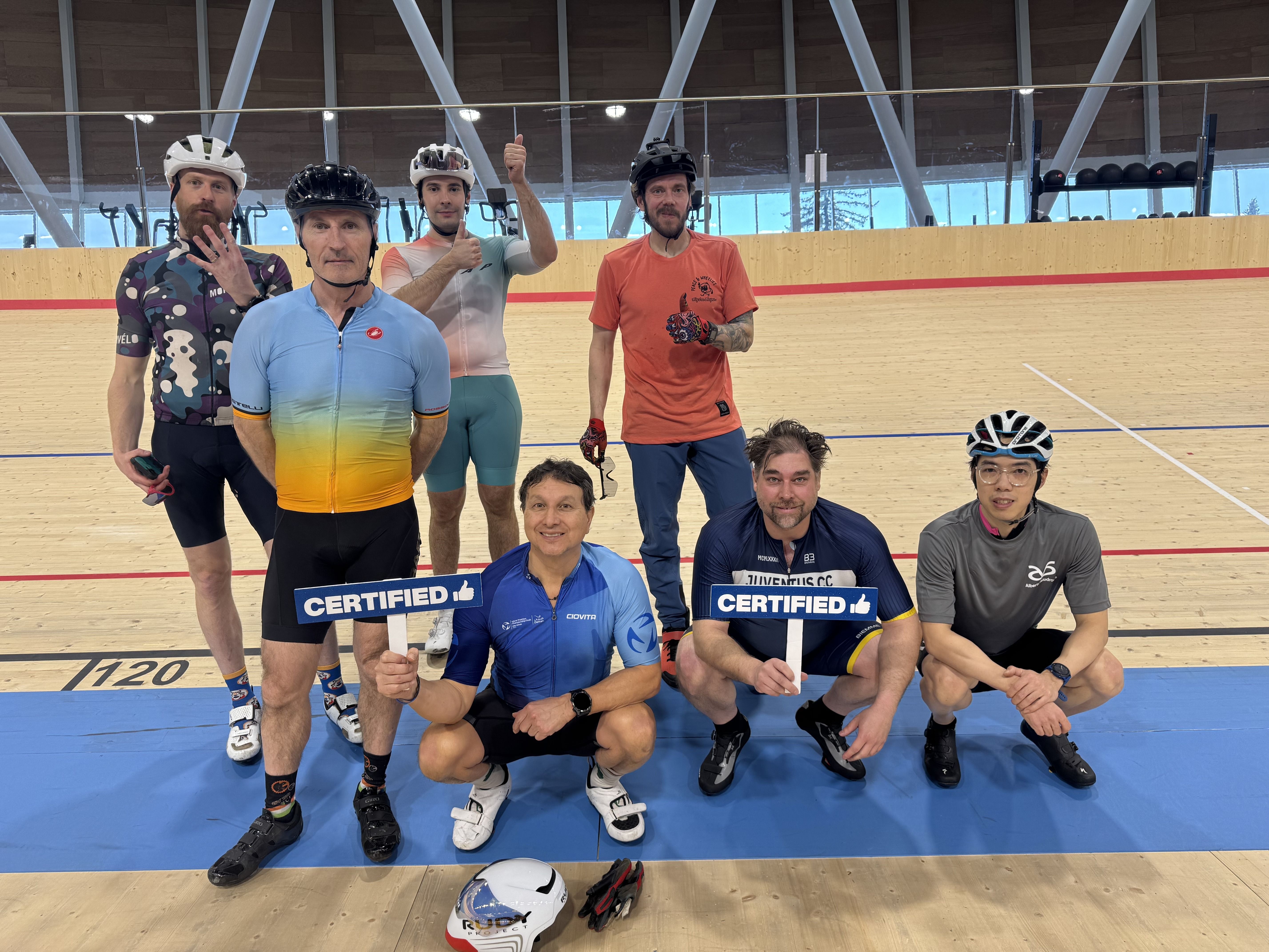 Riders on the track holding "certified" signs after completing the Beginner Pathway