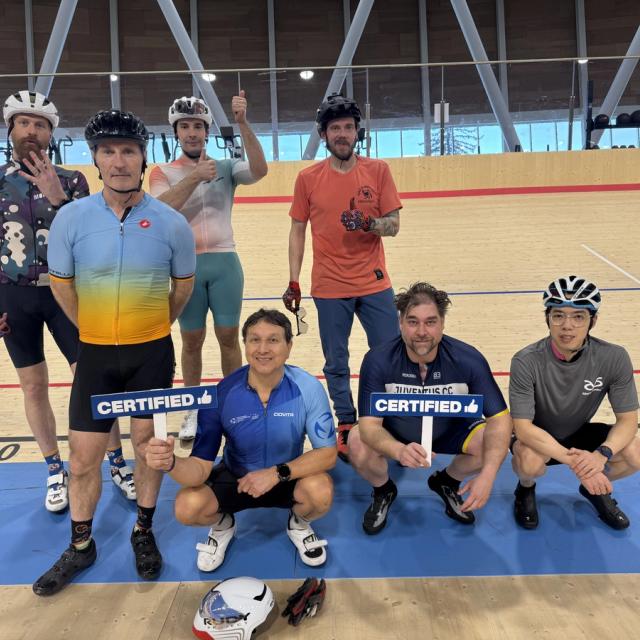 Riders on the track holding "certified" signs after completing the Beginner Pathway