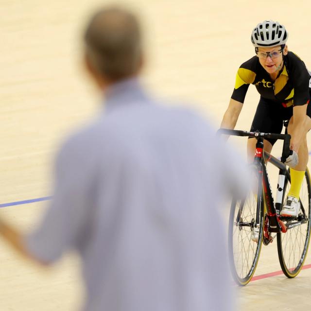 A coach signals to a rider from the infield