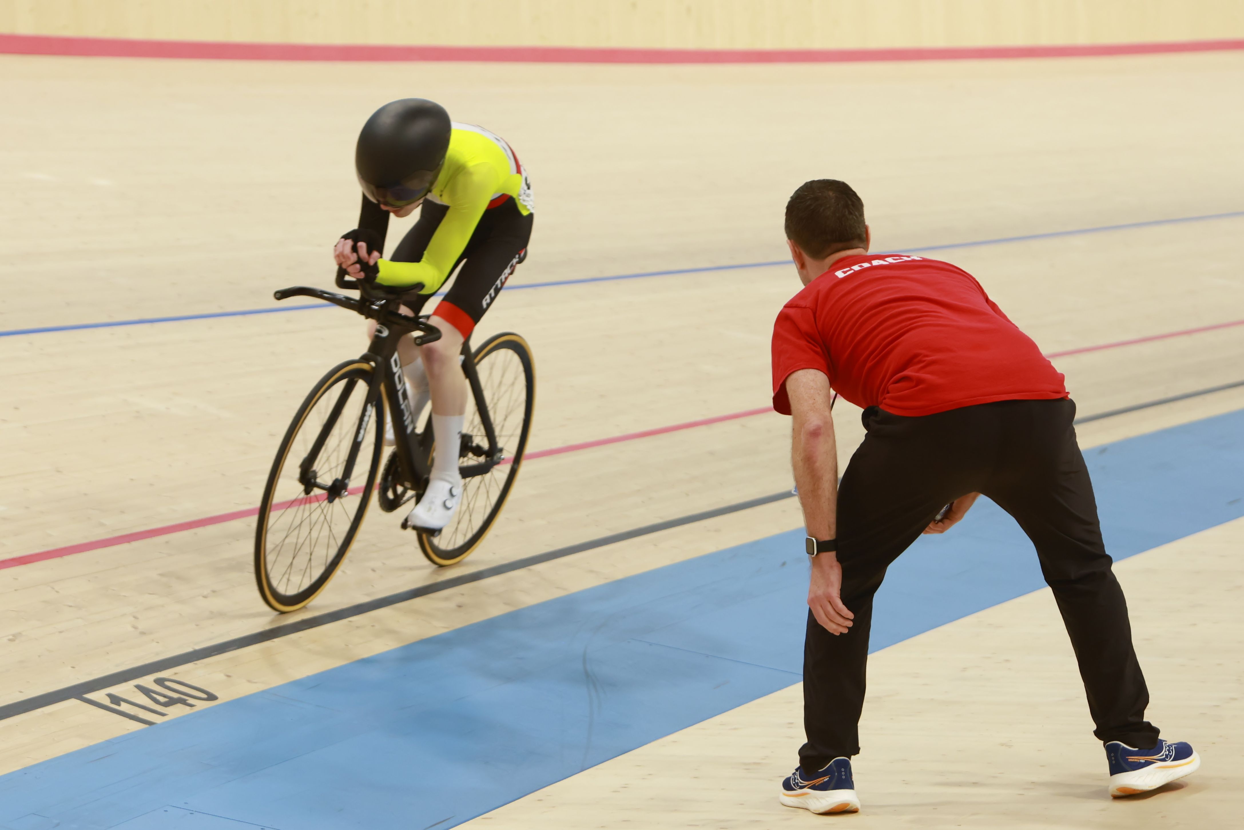 A coach steadies a young rider at the start line