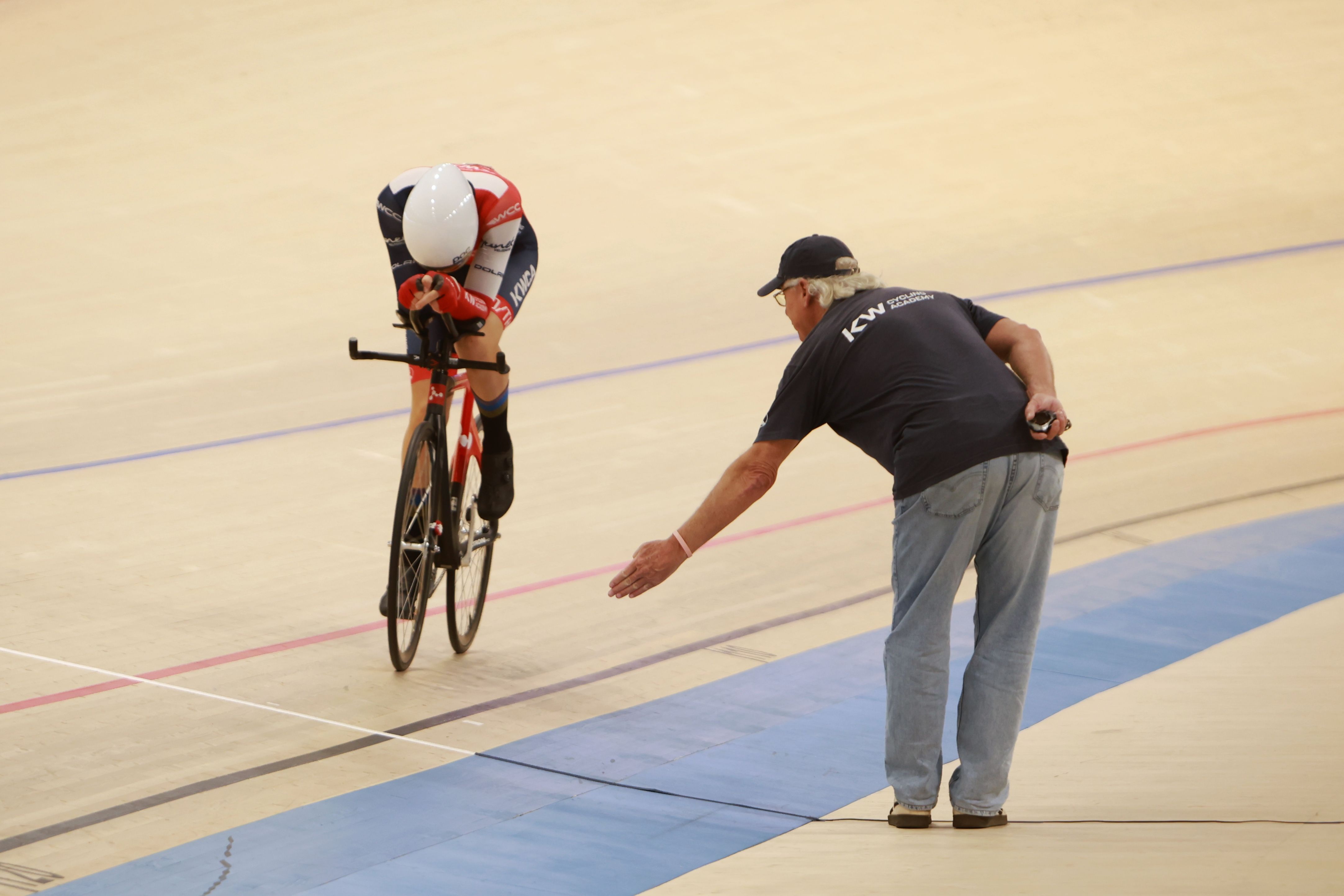A holder steadies a rider before a standing start