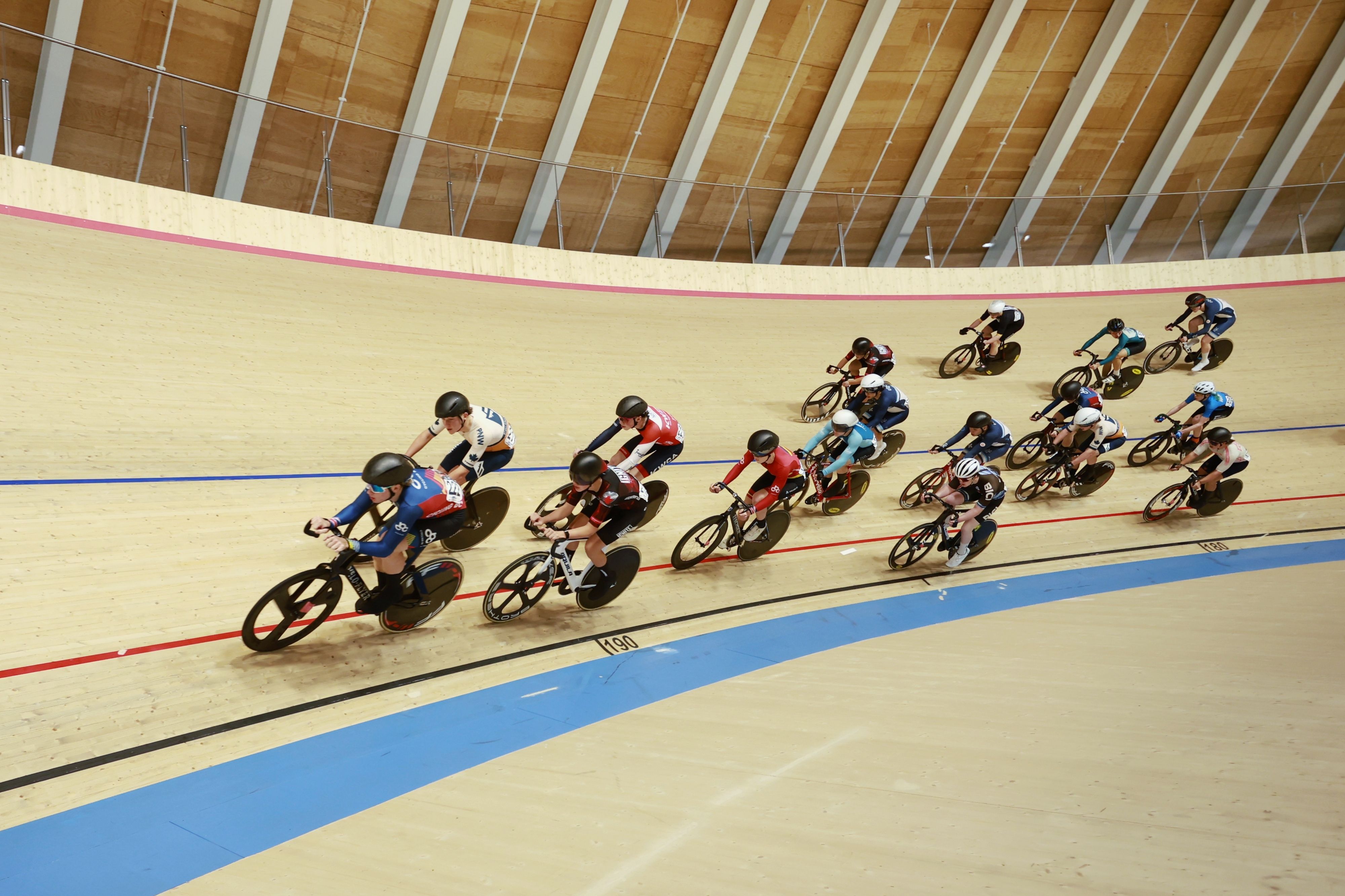 The bunch rounds the banking under the Alberta Velodrome's timber roof