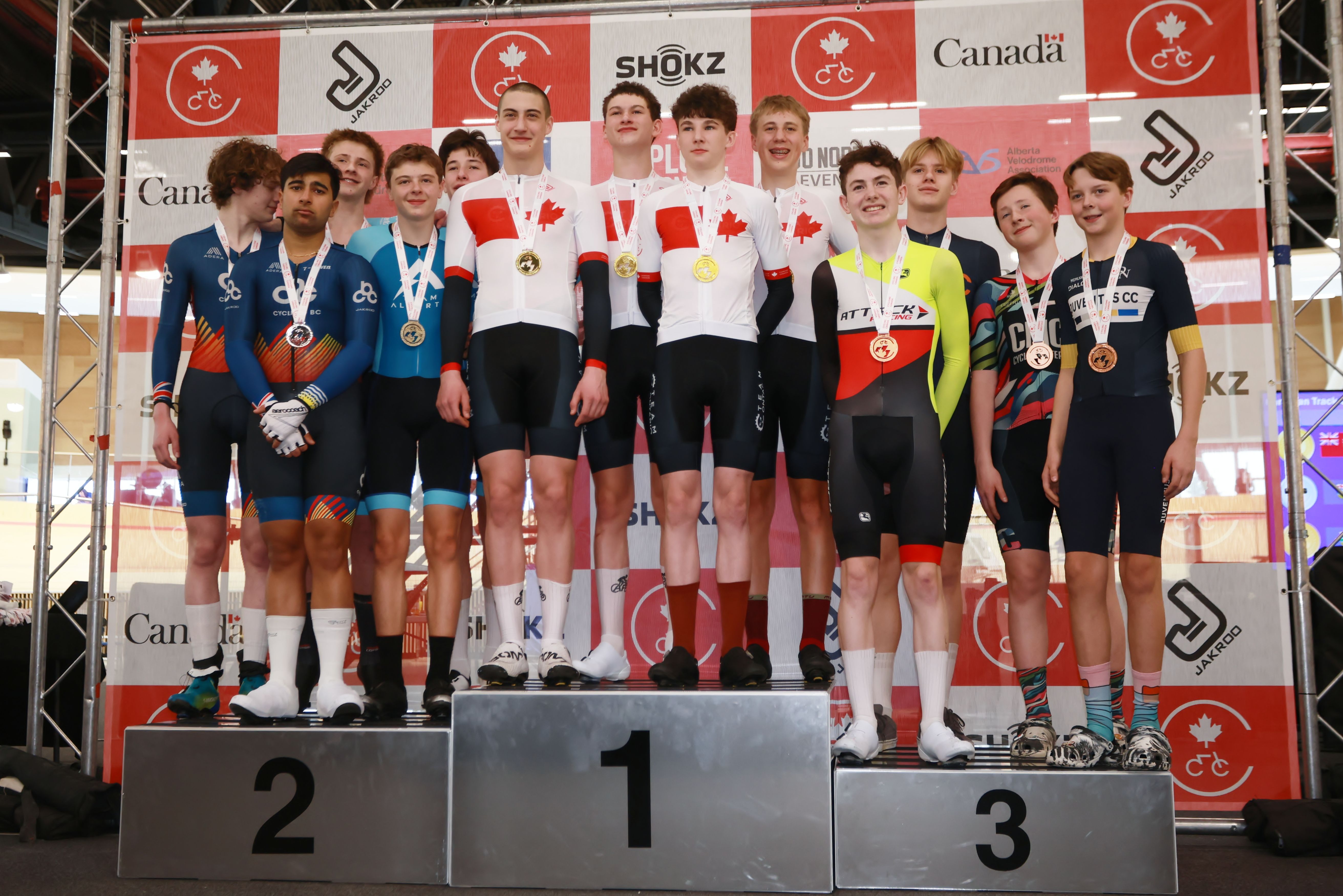 Medallists on the podium in front of the sponsor backdrop