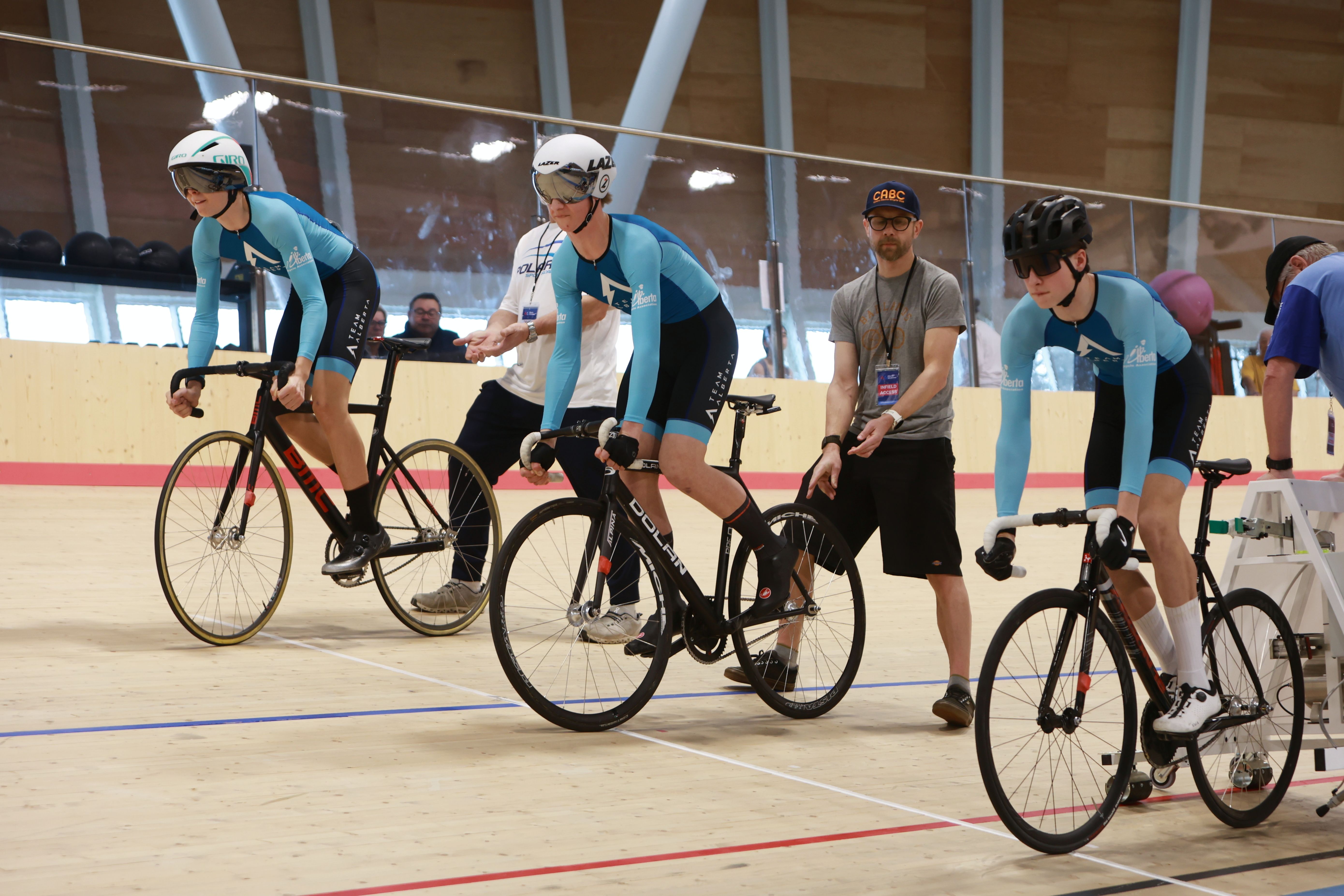 Young riders gather with a coach on the track