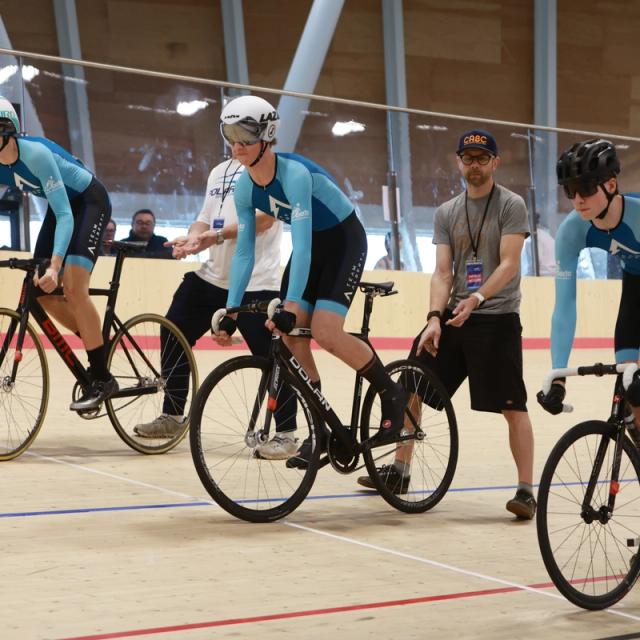Young riders gather with a coach on the track