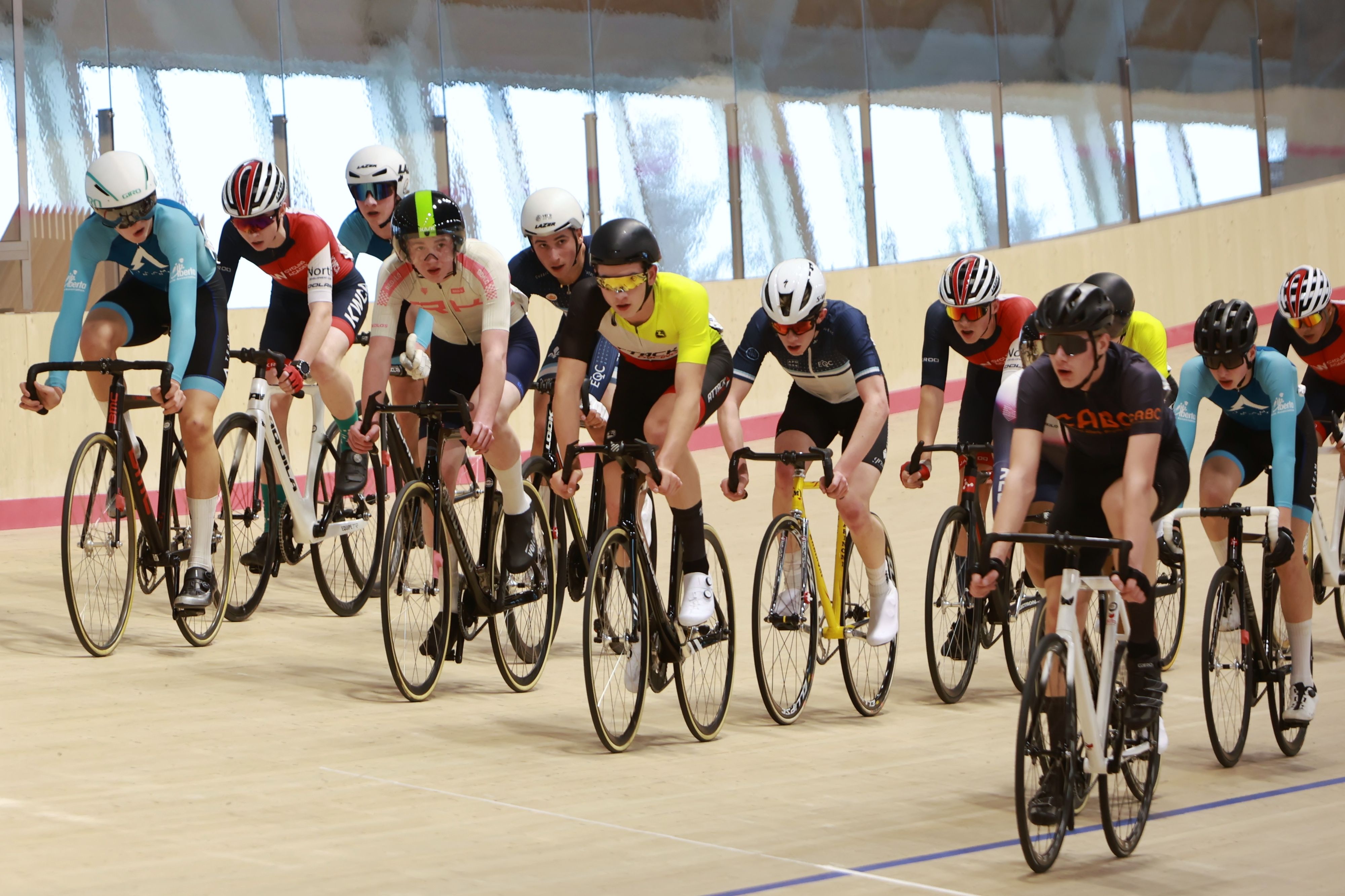 A pack of junior riders sprinting shoulder to shoulder