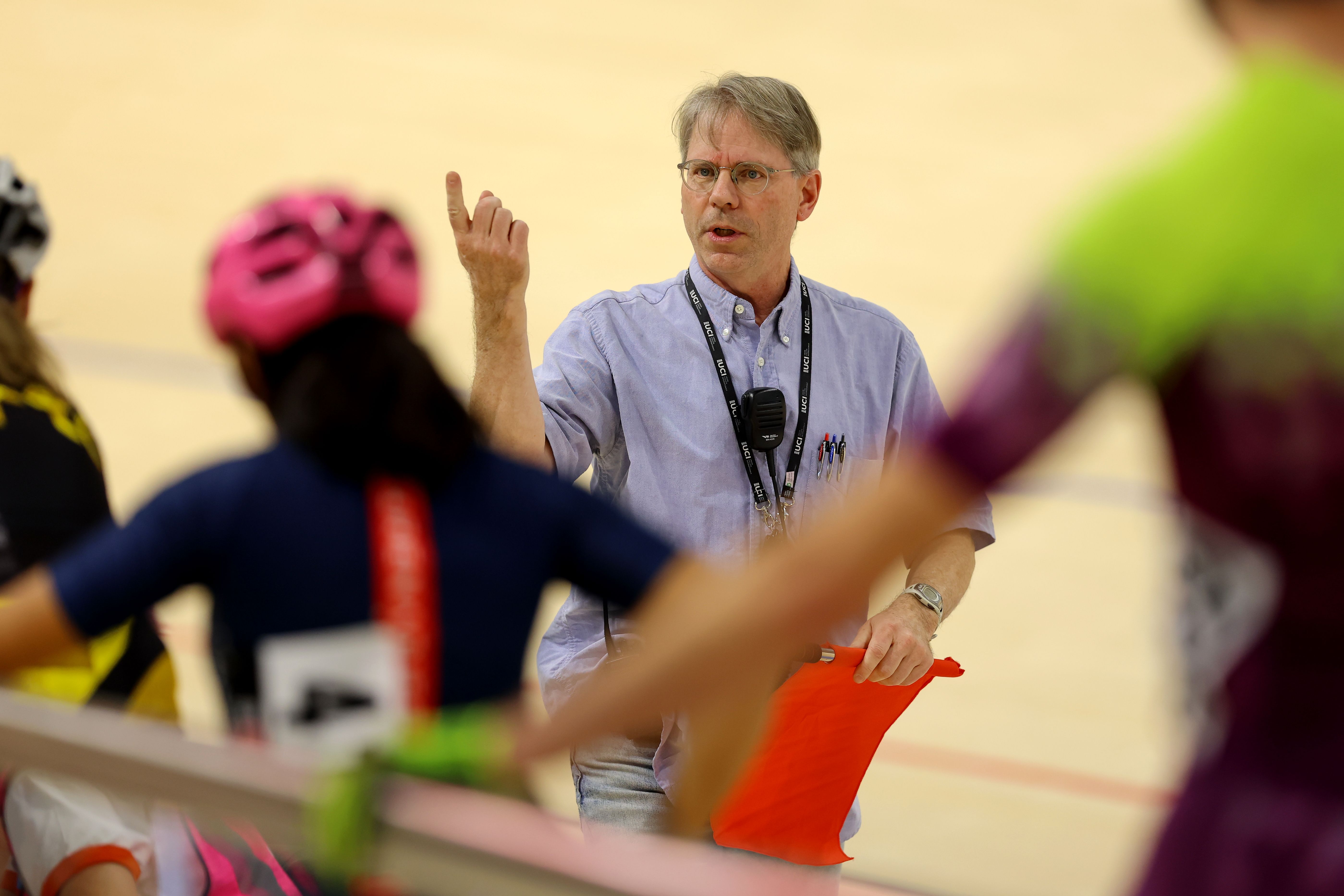A coach explains a session to riders on the track