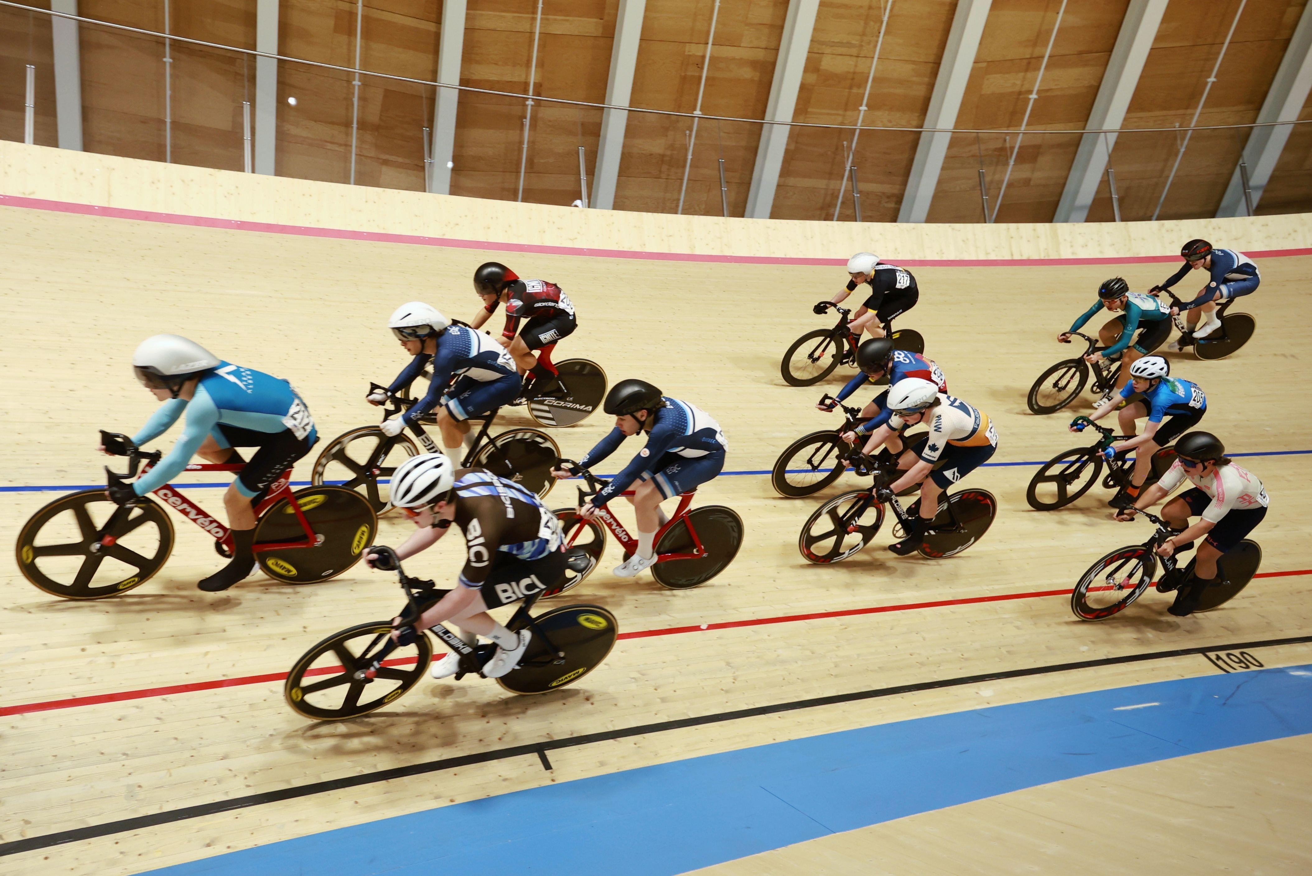 Riders sweep around the banking beneath the roof
