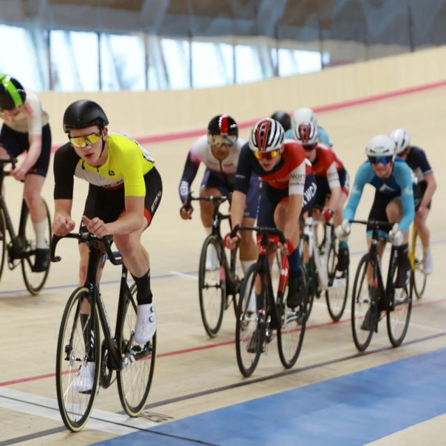 Two riders sprint side by side on the banking