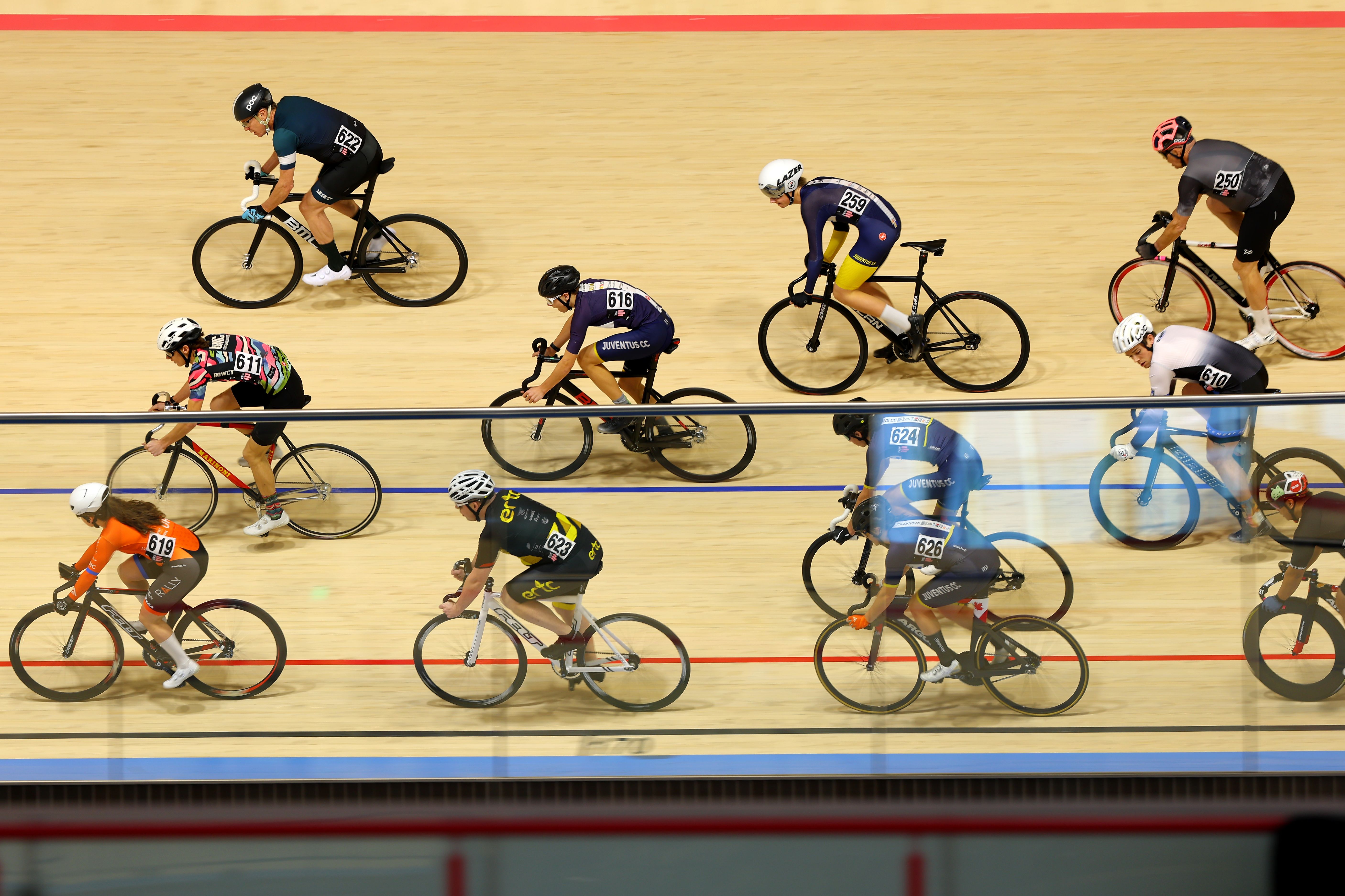 Adult riders racing in a bunch on the Alberta Velodrome track