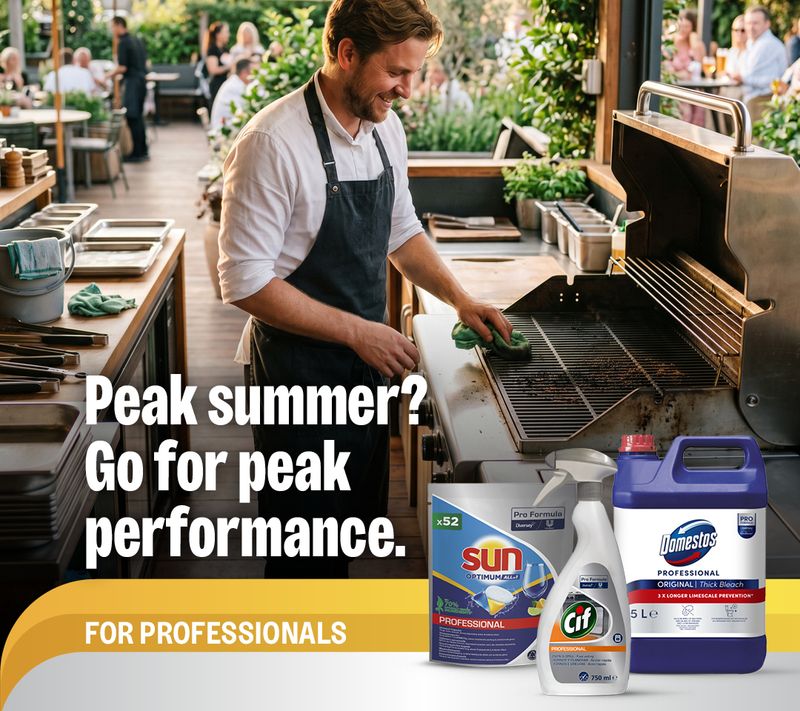 A chef cleans a BBQ grill at an outdoor restaurant while professional cleaning products (Sun, Cif, Domestos) are displayed. Text: "Peak summer? Go for peak performance. FOR PROFESSIONALS."