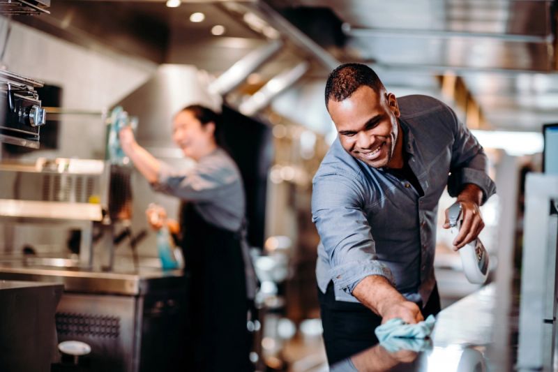 Eine Frau reinigt einen Tisch in einem Restaurant