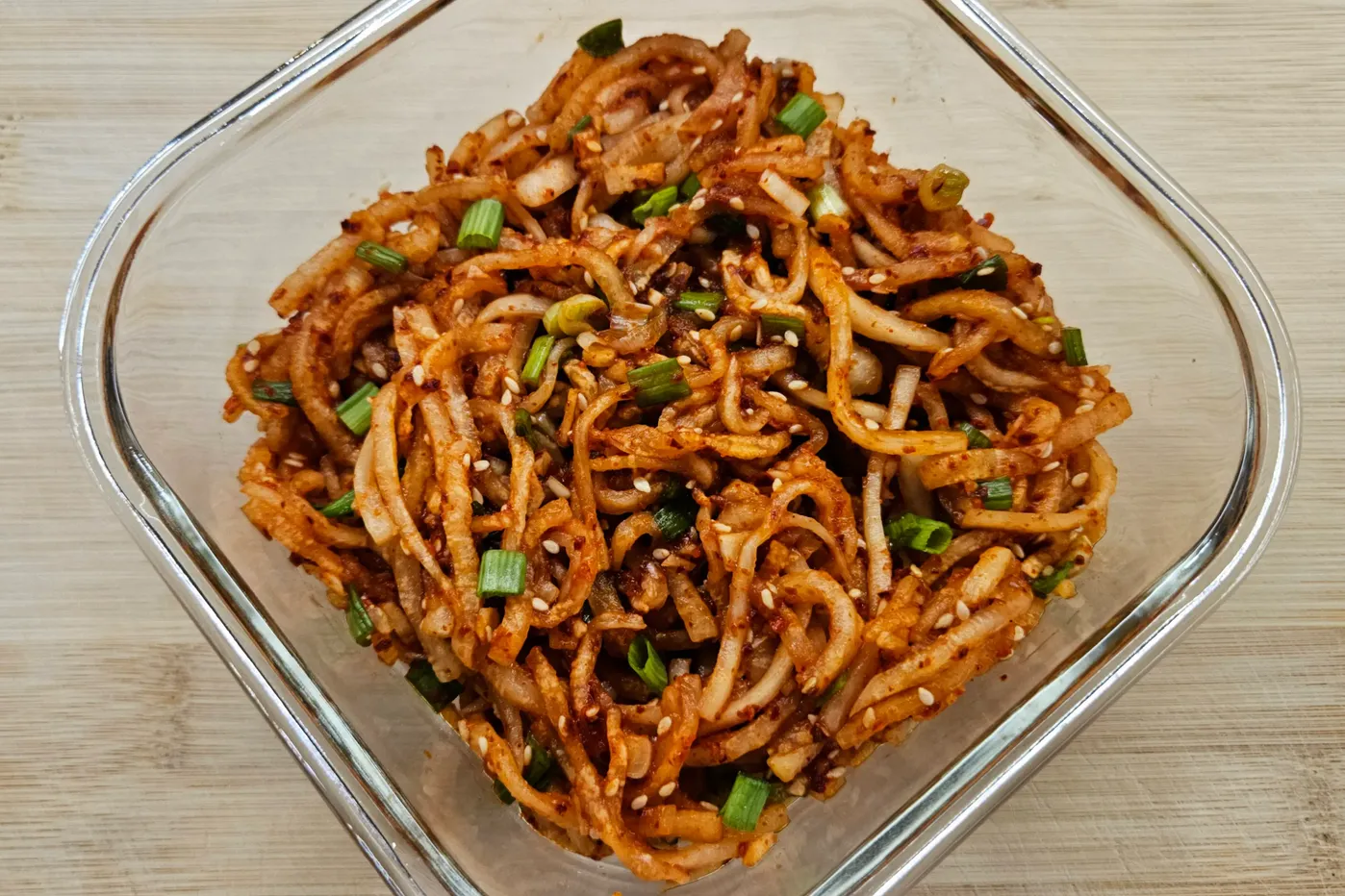 Spicy Korean banchan made with shredded radish, green onions, sesame seeds, and hot pepper.