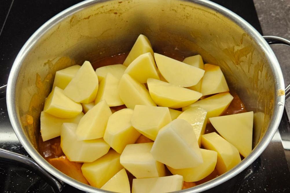 Додаємо нарізану картоплю до тушкованої індички.