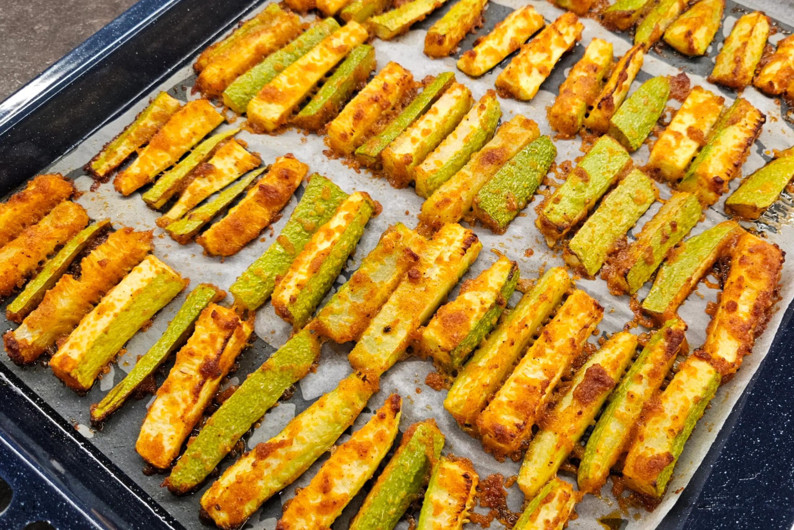 Crispy baked golden zucchini fries with a savory cheese crust right after baking.