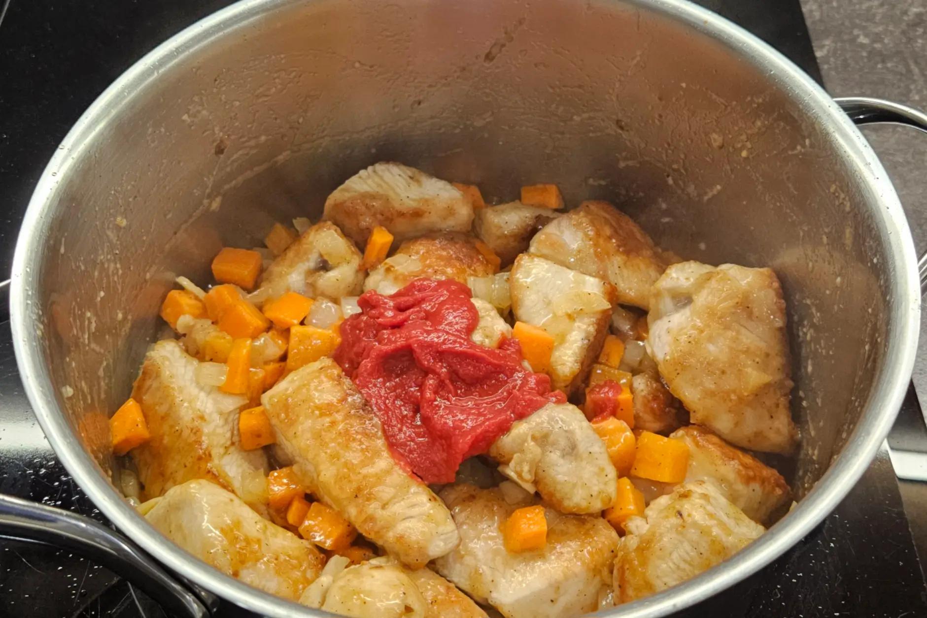 Додаємо цибулю, моркву та томатну пасту до каструлі.