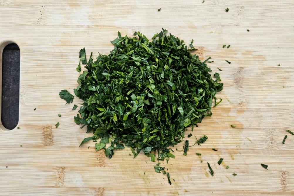 Подрібнення свіжої петрушки після промивання.