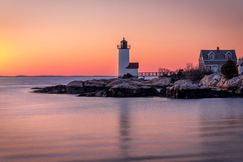 Yellow and magenta smooth sky with a gorgeous lighthouse and smooth water reflections