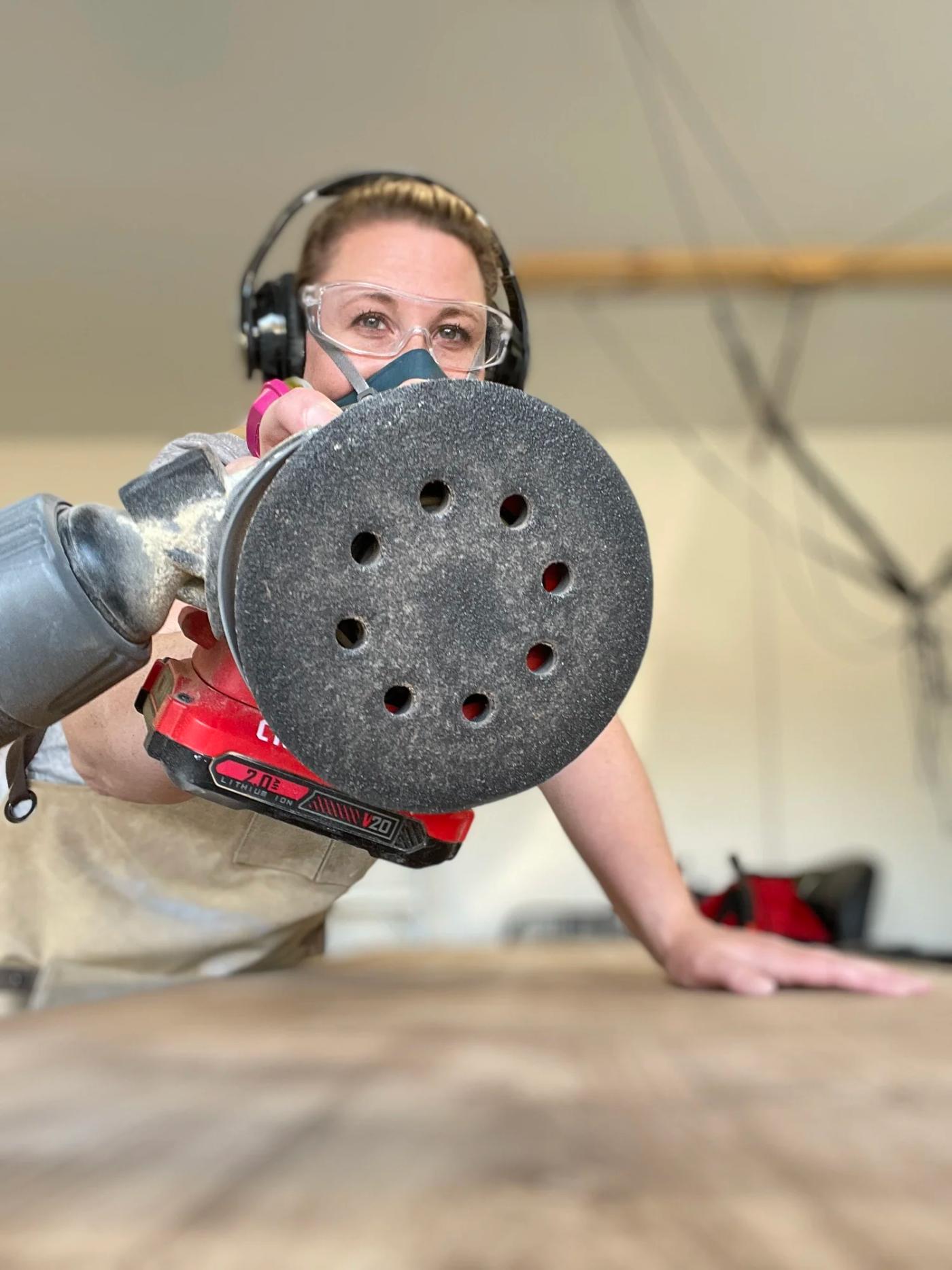 Sanding every piece smooth — safety glasses, ear muffs, and all