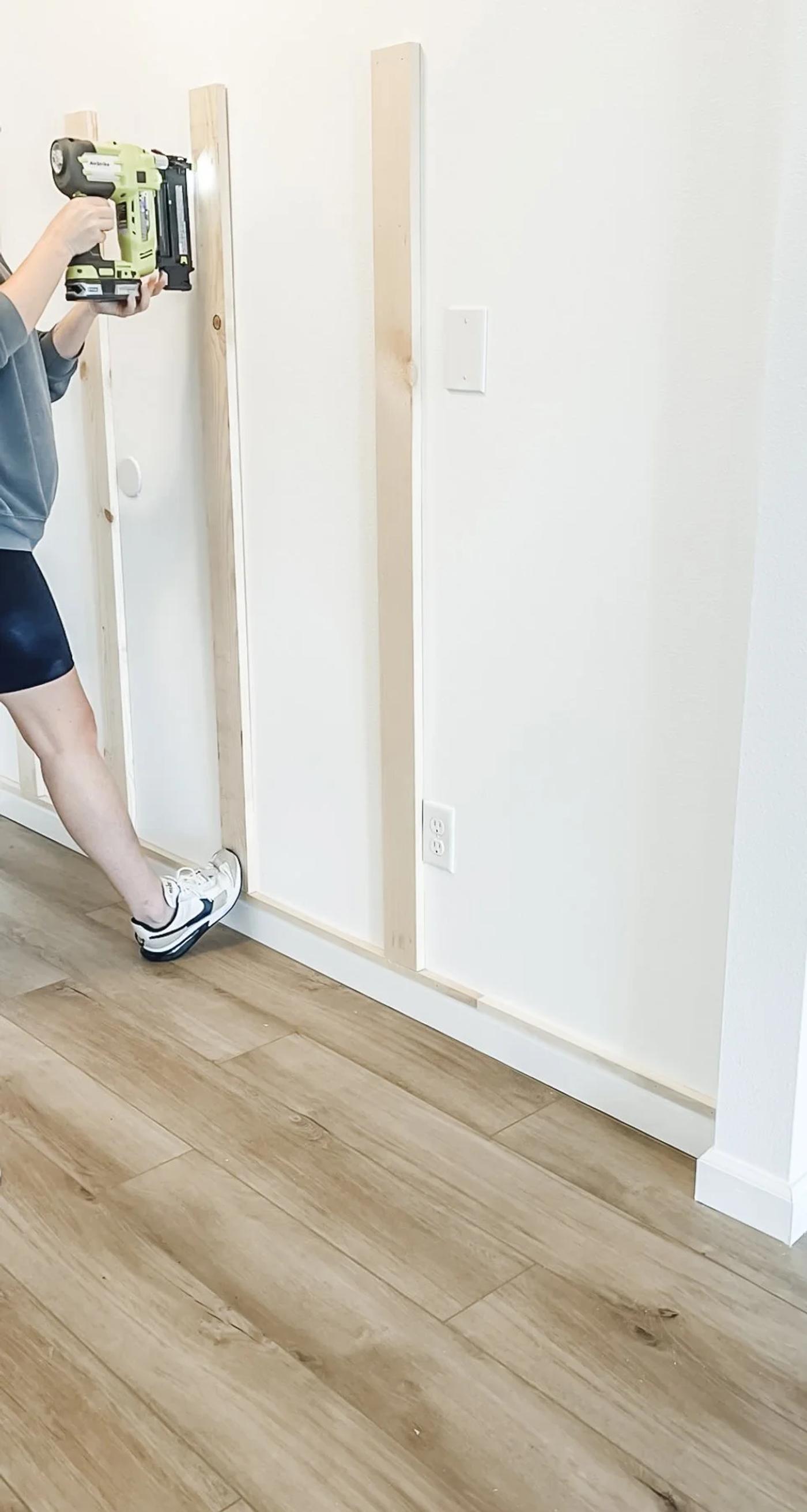 Nailing the vertical slats to the wall, level and evenly spaced