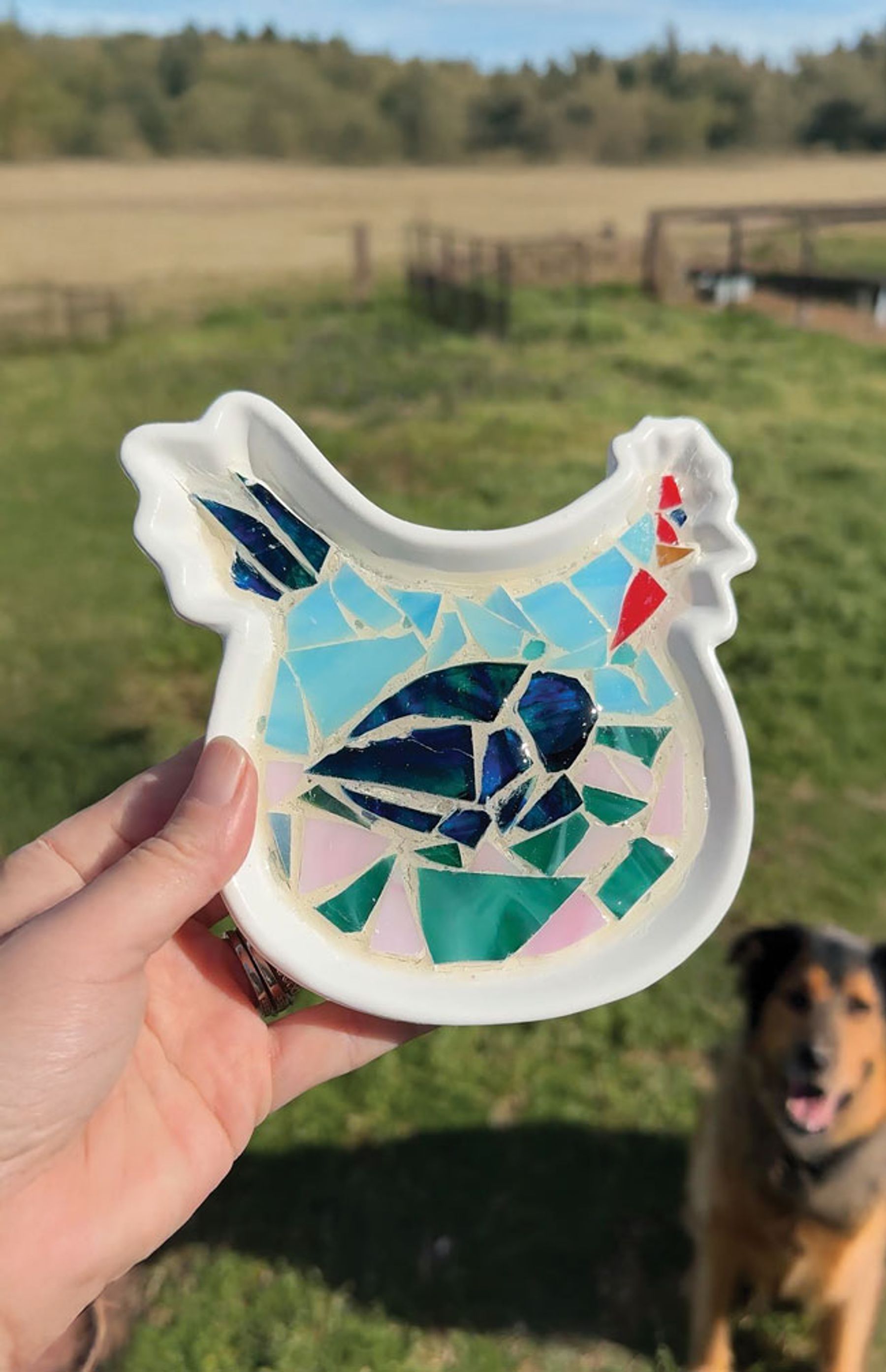 A small ceramic dish covered in a colorful glass mosaic with grout between the pieces
