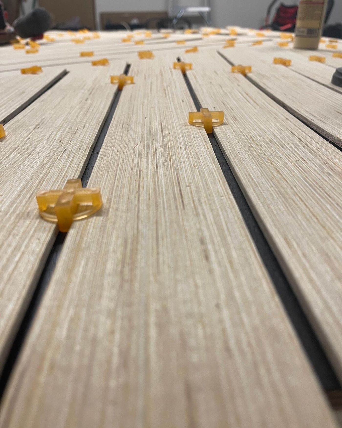 Tile spacers keeping every gap perfectly even while the slats go down