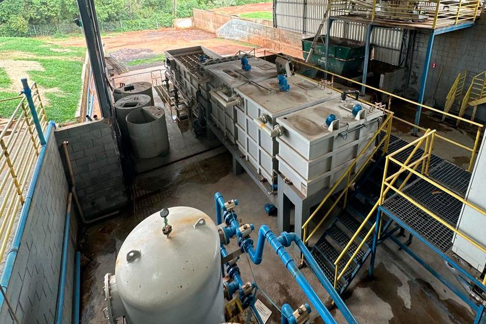 Instalação industrial da central de resíduos de Cascavel, com tanques, tubulações azuis e passarelas com guarda-corpos amarelos.