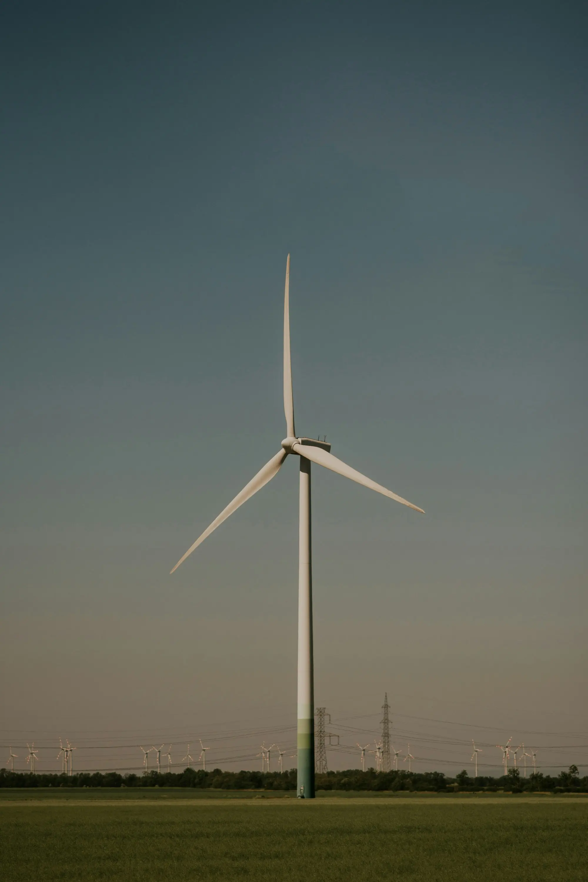 Single wind turbine in a field under a clear sky.