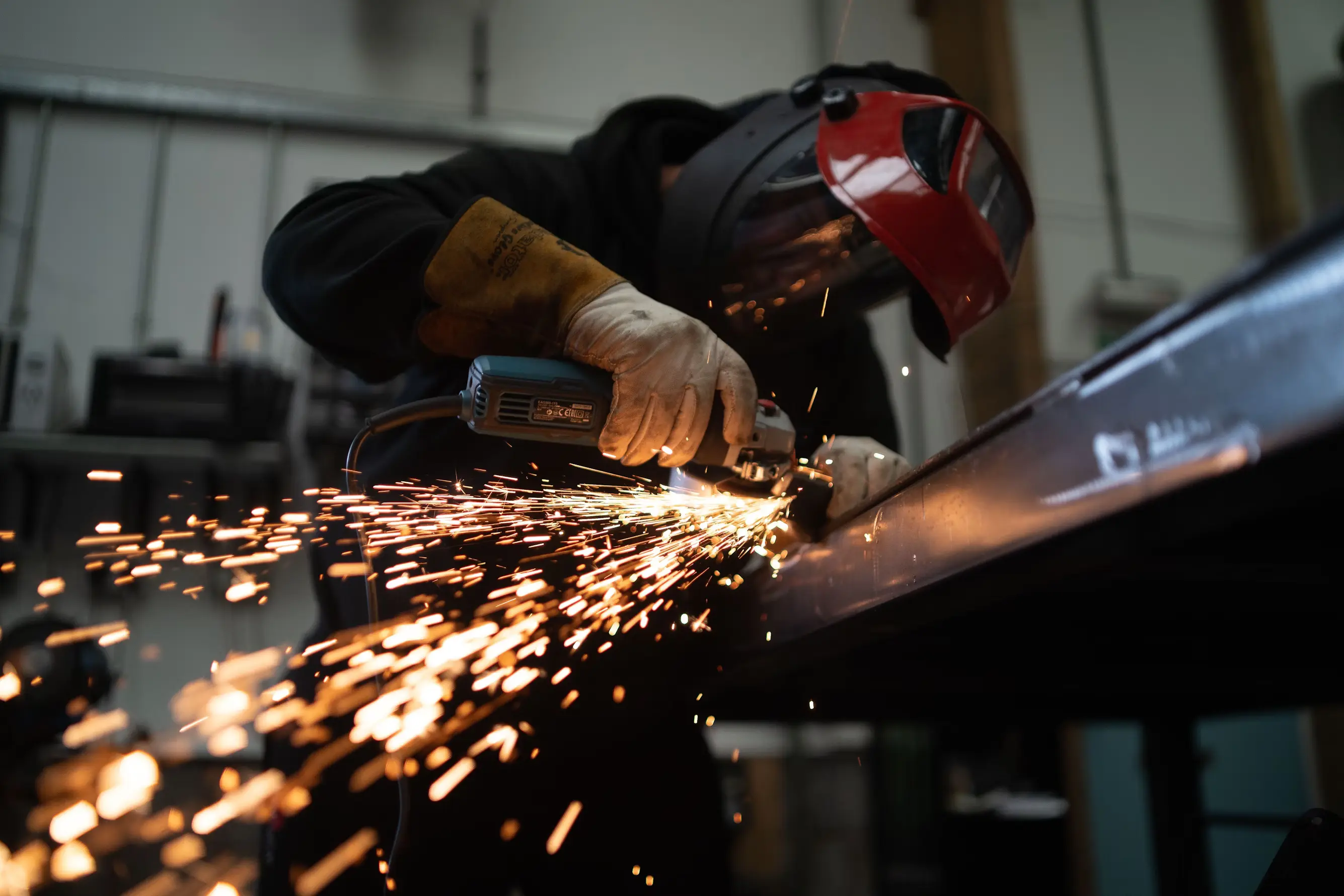 Worker using a metal grinder with sparks flying.