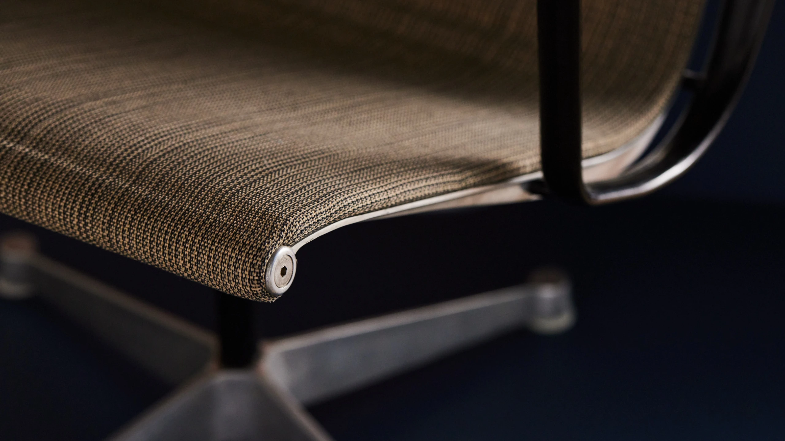 Close up view of Eames Aluminum Group chair.