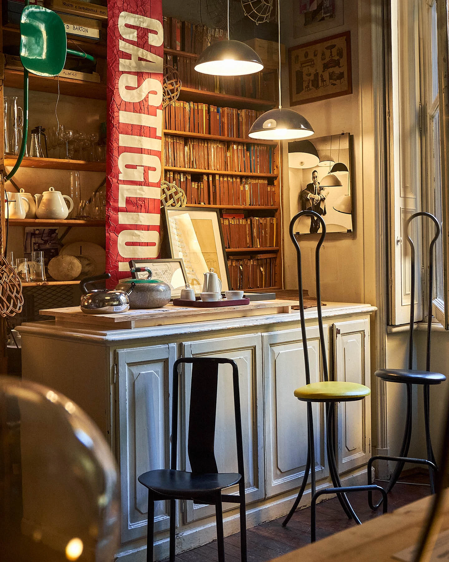 Tea kettles, ceramics, and technical design drawings on a table in the studio of Achille Castiglioni in Milan.
