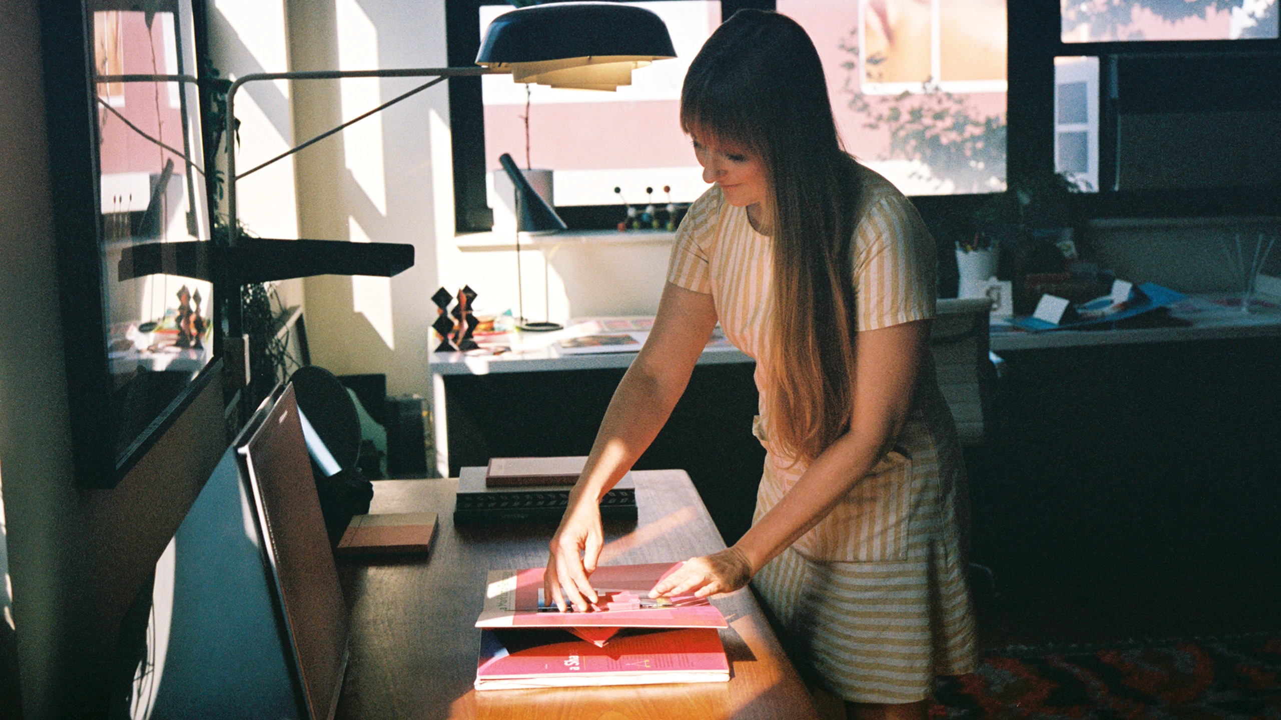 Designer and paper engineer Kelli Anderson at a table with her pop-up book “Alphabet in Motion.”