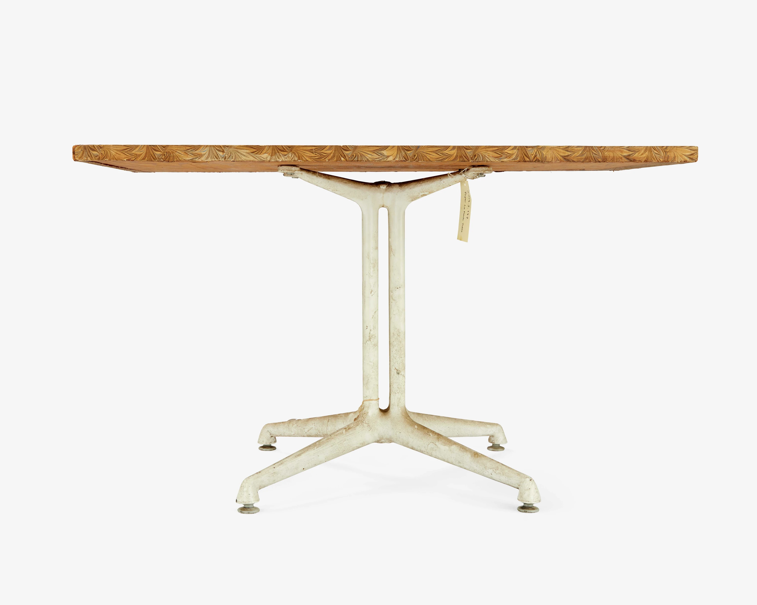 Side view of the Eames Special Use Table with a four column pedestal aluminum base and a plywood and marbled paper top.