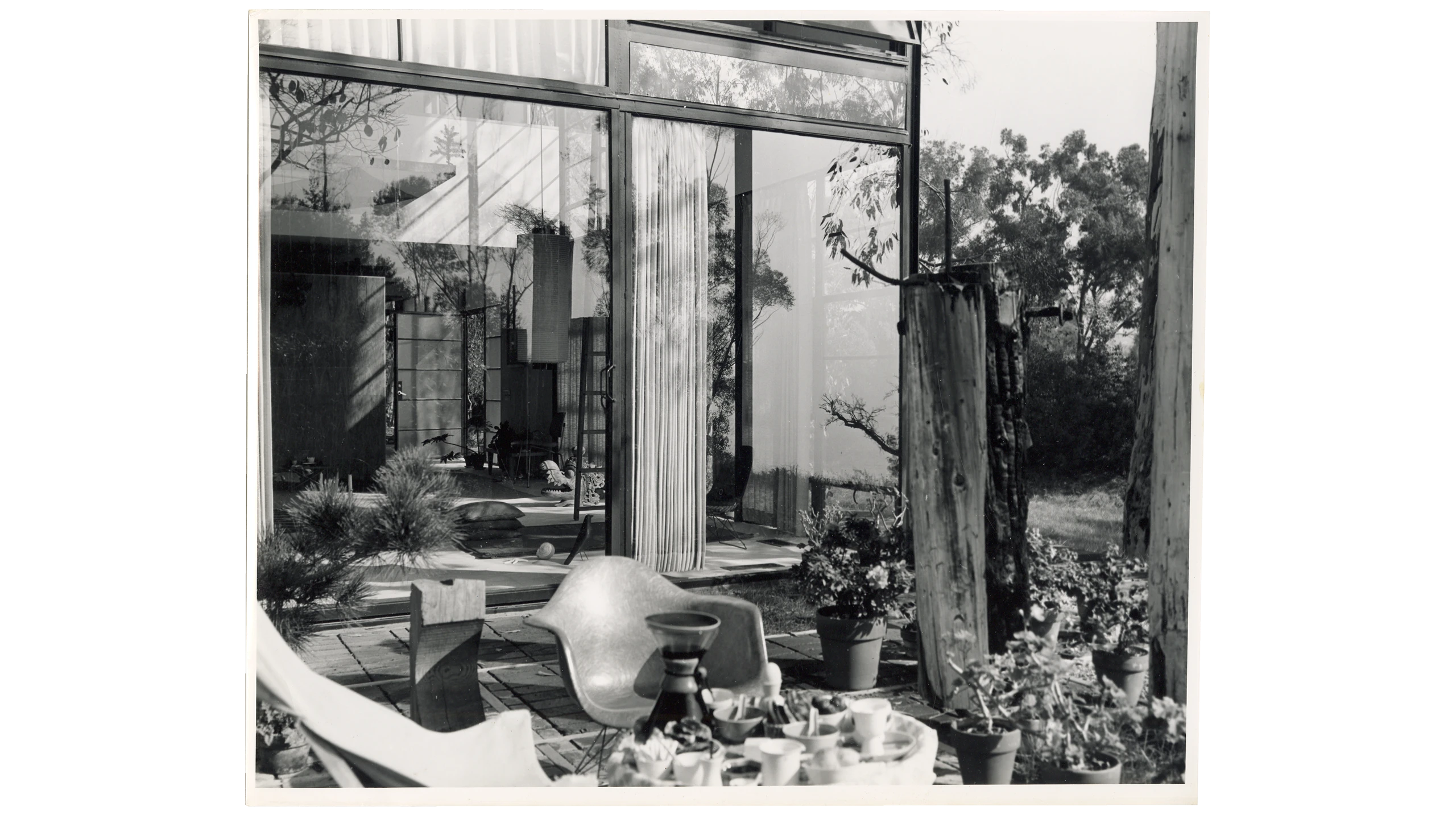 Eames Case Study House 8 exterior featuring a wall of windows from the patio reflects its modernist design.