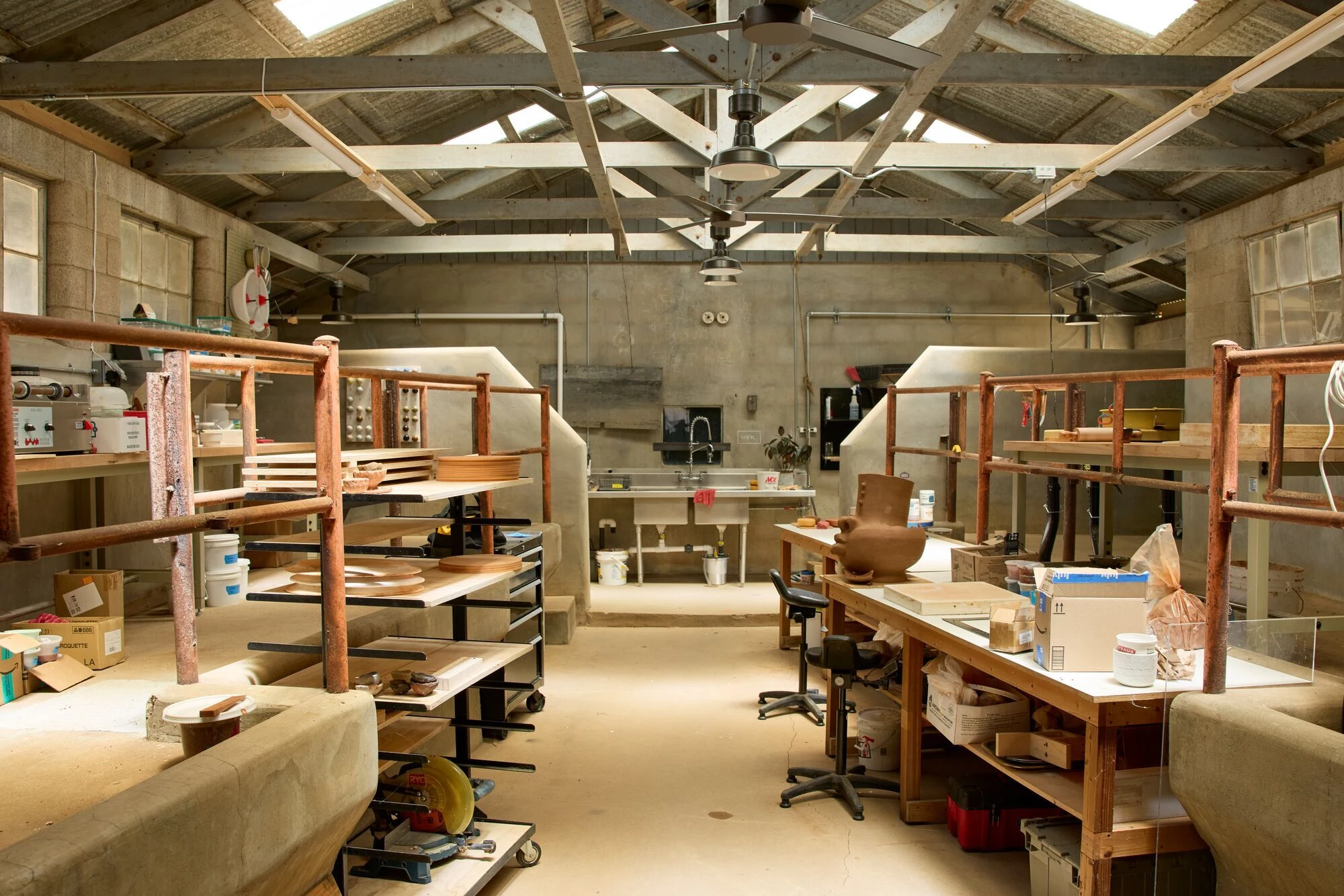 The ceramics studio at the Eames Ranch with several pieces drying on shelves.