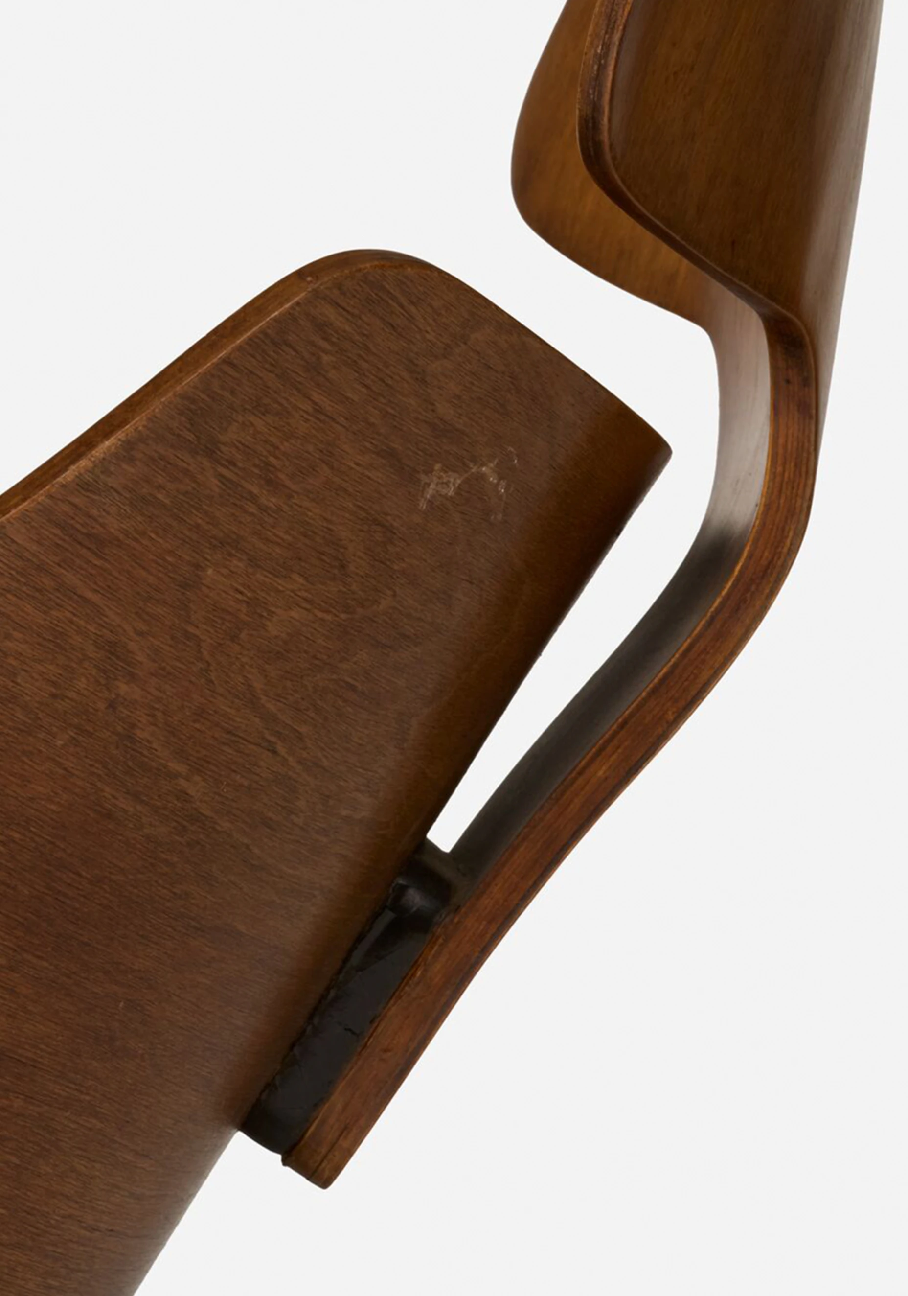 Close up side view of an Eames Lounge Chair prototype made with molded plywood.