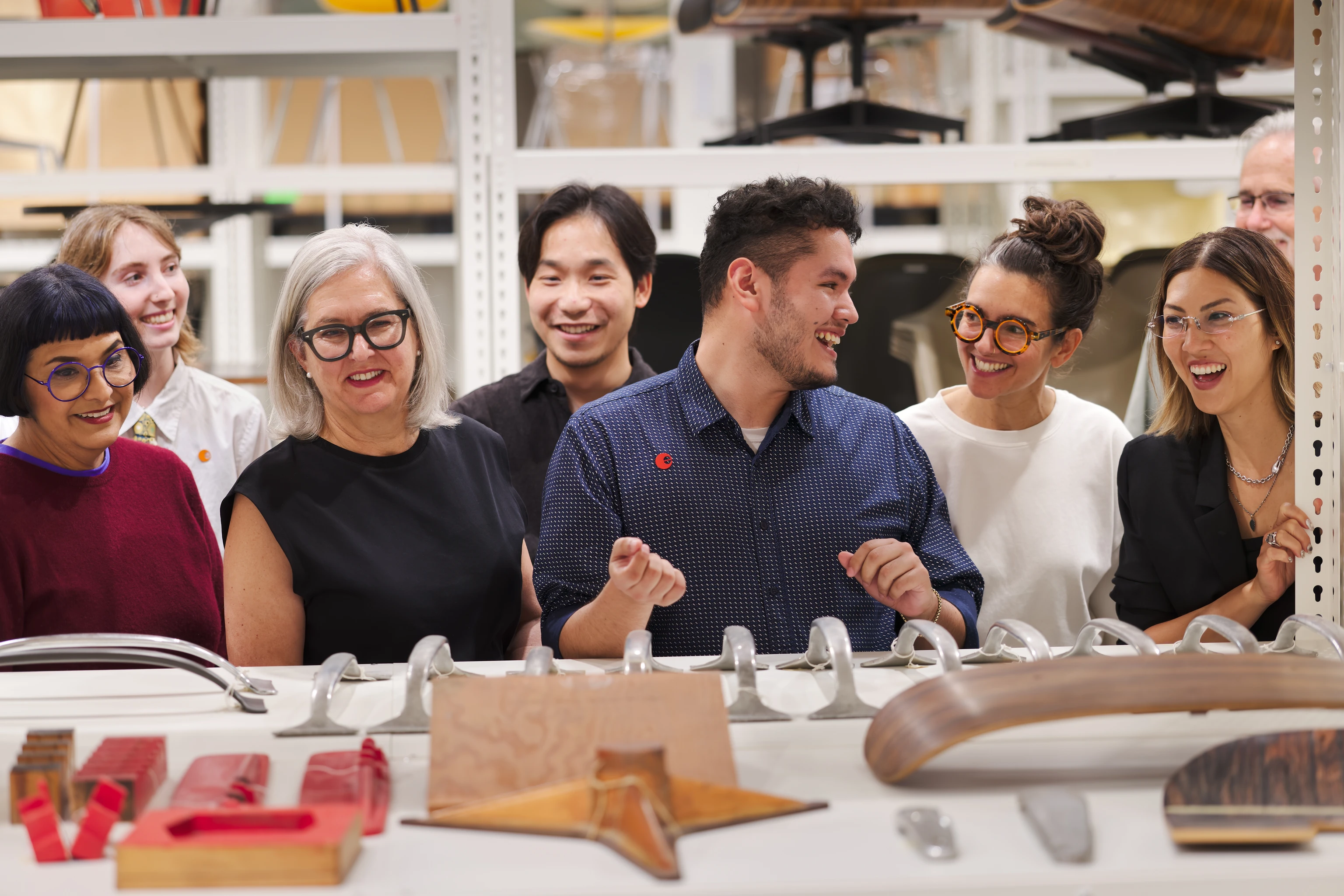 Visitors at the Eames Archives Collections Center, viewing furniture components and prototypes from the Eames collection.
