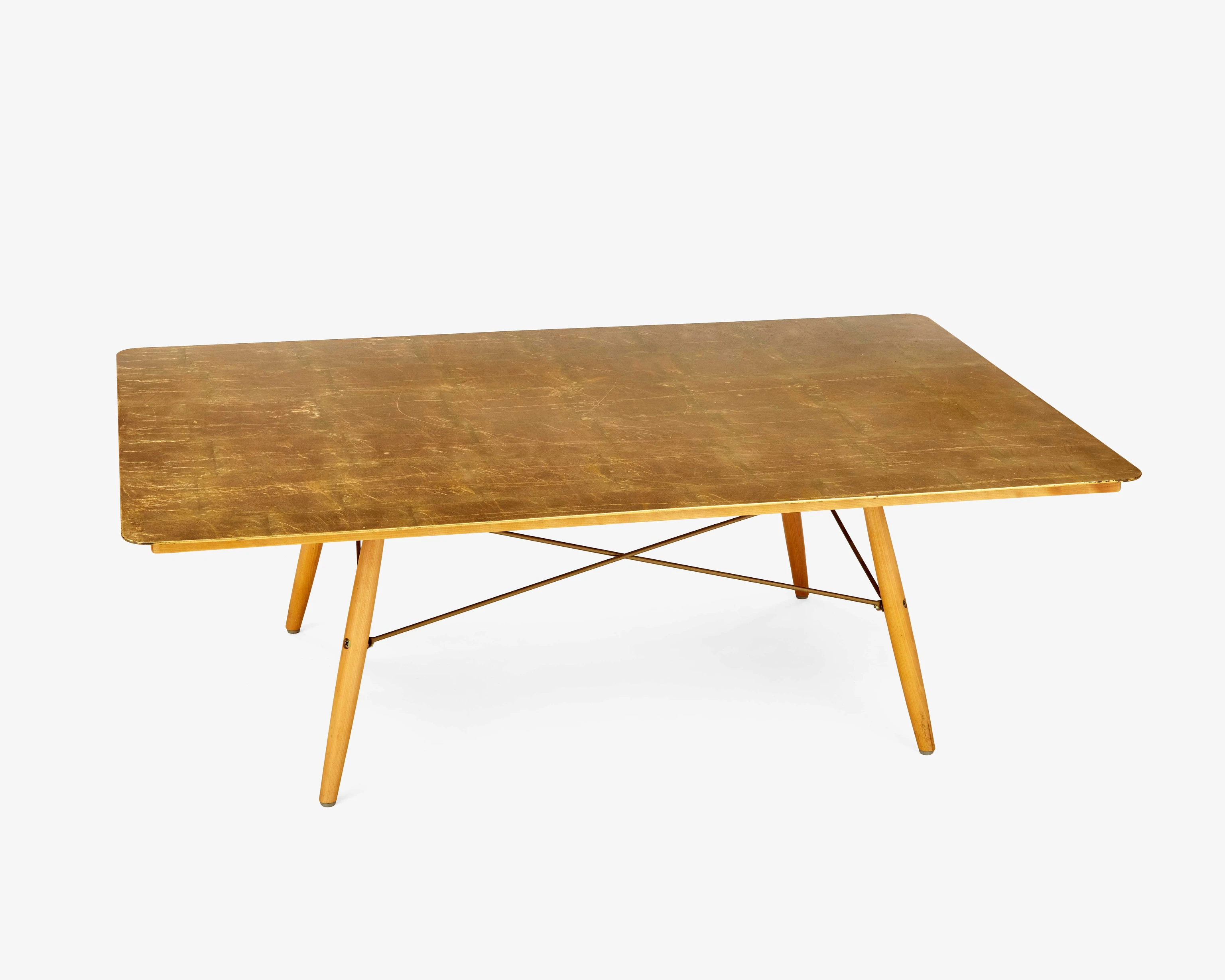 The Eames House Anniversary Table with a gold leaf top and wood-dowel-and-steel-rod base.
