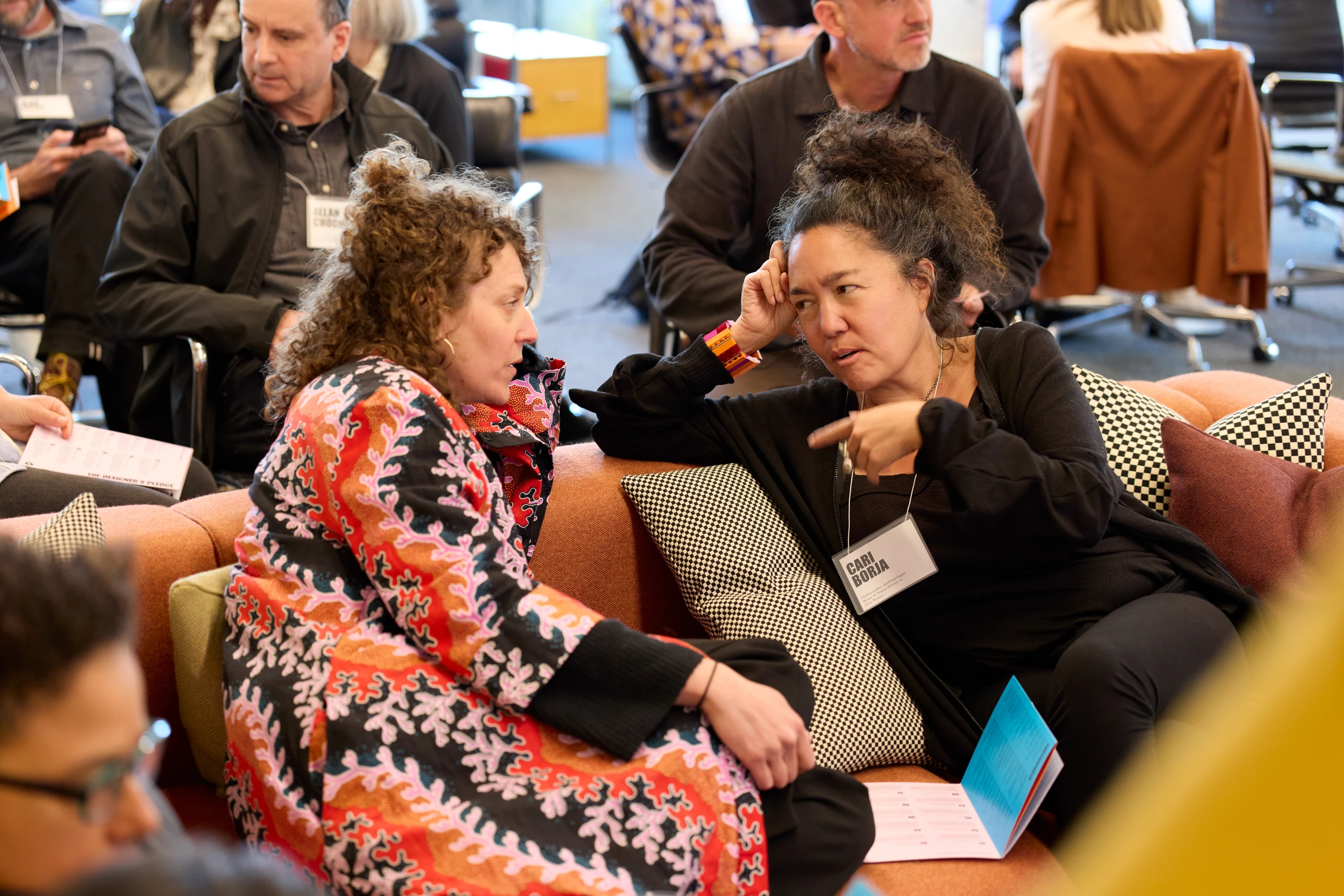 A conversation between two people on a couch during a Design Vanguard convening at the Eames Institute